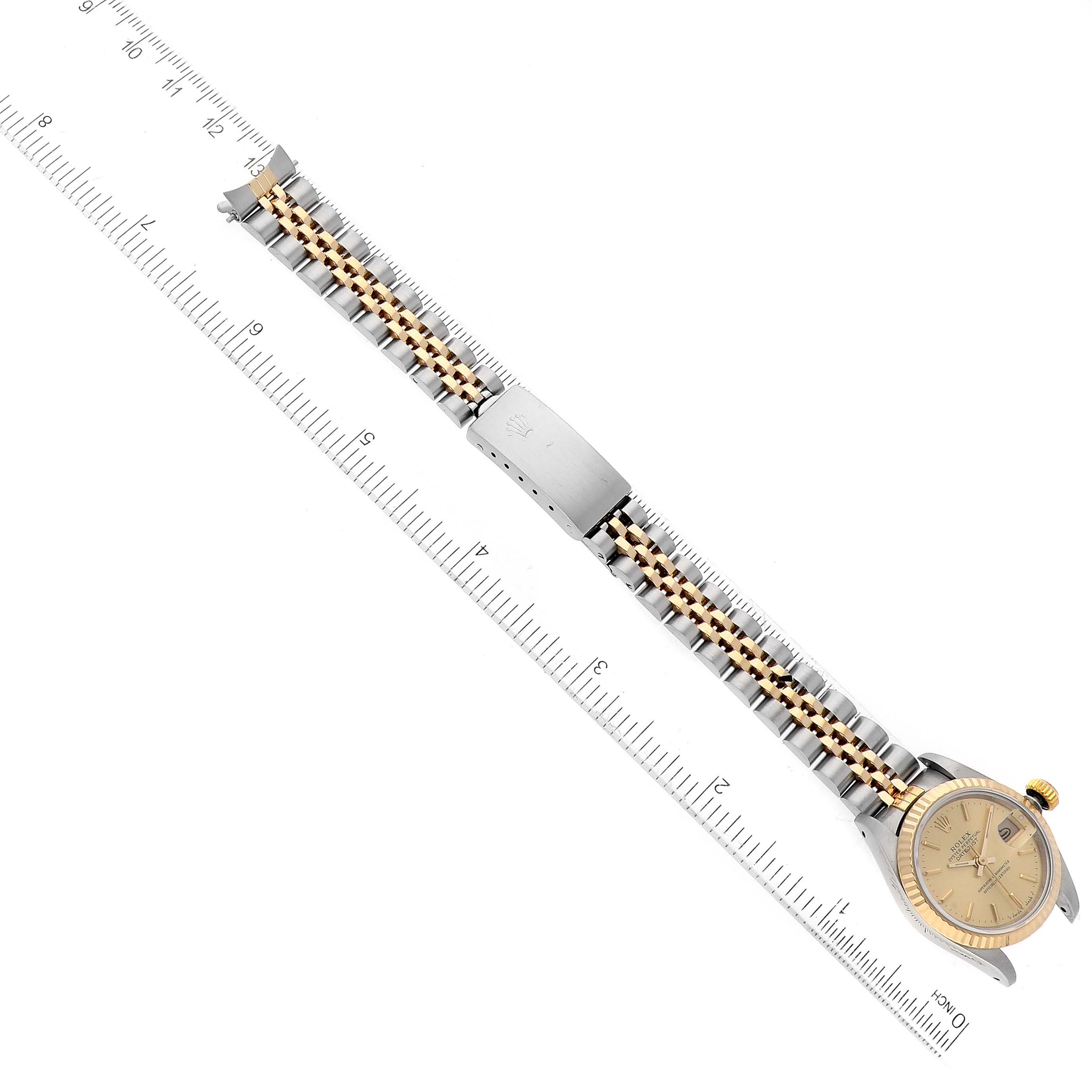 The image shows a Rolex Datejust 69173 Women's Steel and Gold (two tone) Champagne Dial 69173 Women's Steel and Gold (two tone) Champagne Dial watch from a top-down angle, highlighting its face, bracelet, and clasp against a measuring ruler.