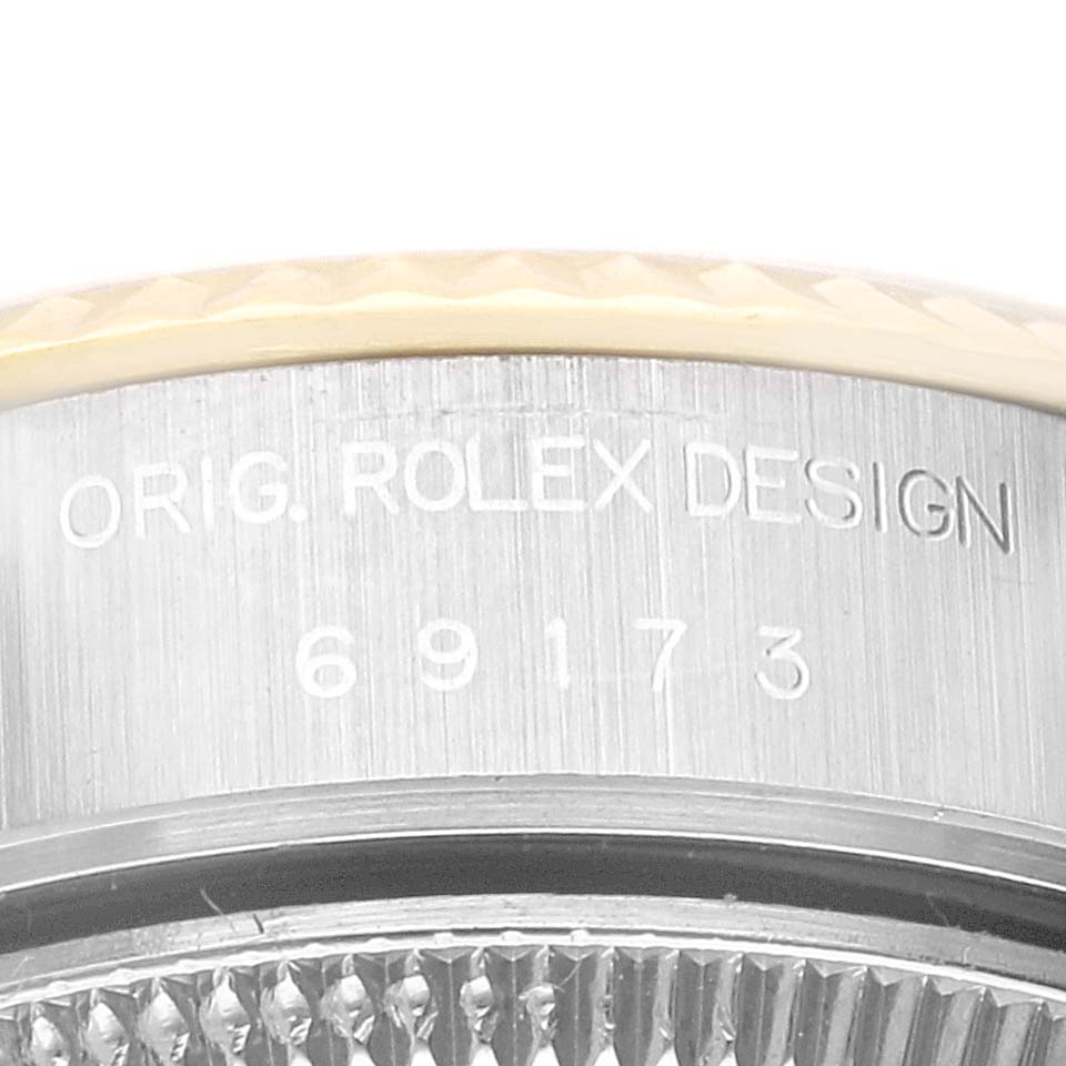 This close-up image shows the case side of a Rolex Datejust 69173 Women's Steel and Gold (two tone) Champagne Dial 69173 Women's Steel and Gold (two tone) Champagne Dial watch, featuring the engraving "ORIG. ROLEX DESIGN" and the model number 69173.