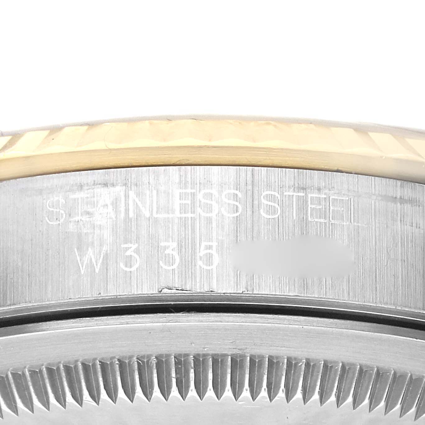 This image shows a close-up of the side of a Rolex Datejust 16233 Men's Steel and Gold (two tone) Champagne Dial 16233 Men's Steel and Gold (two tone) Champagne Dial watch, focusing on the bezel and engraved serial number on the stainless steel case.