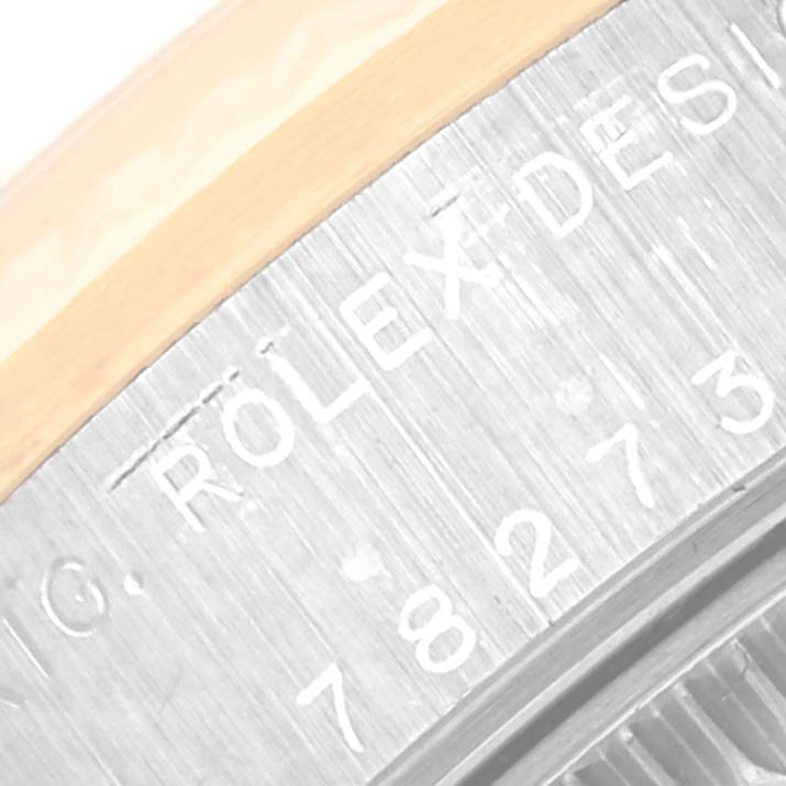Close-up of the engraved case back edge of a Mid-Size Rolex watch, showing part of the serial number and "ROLEX DESIGN".