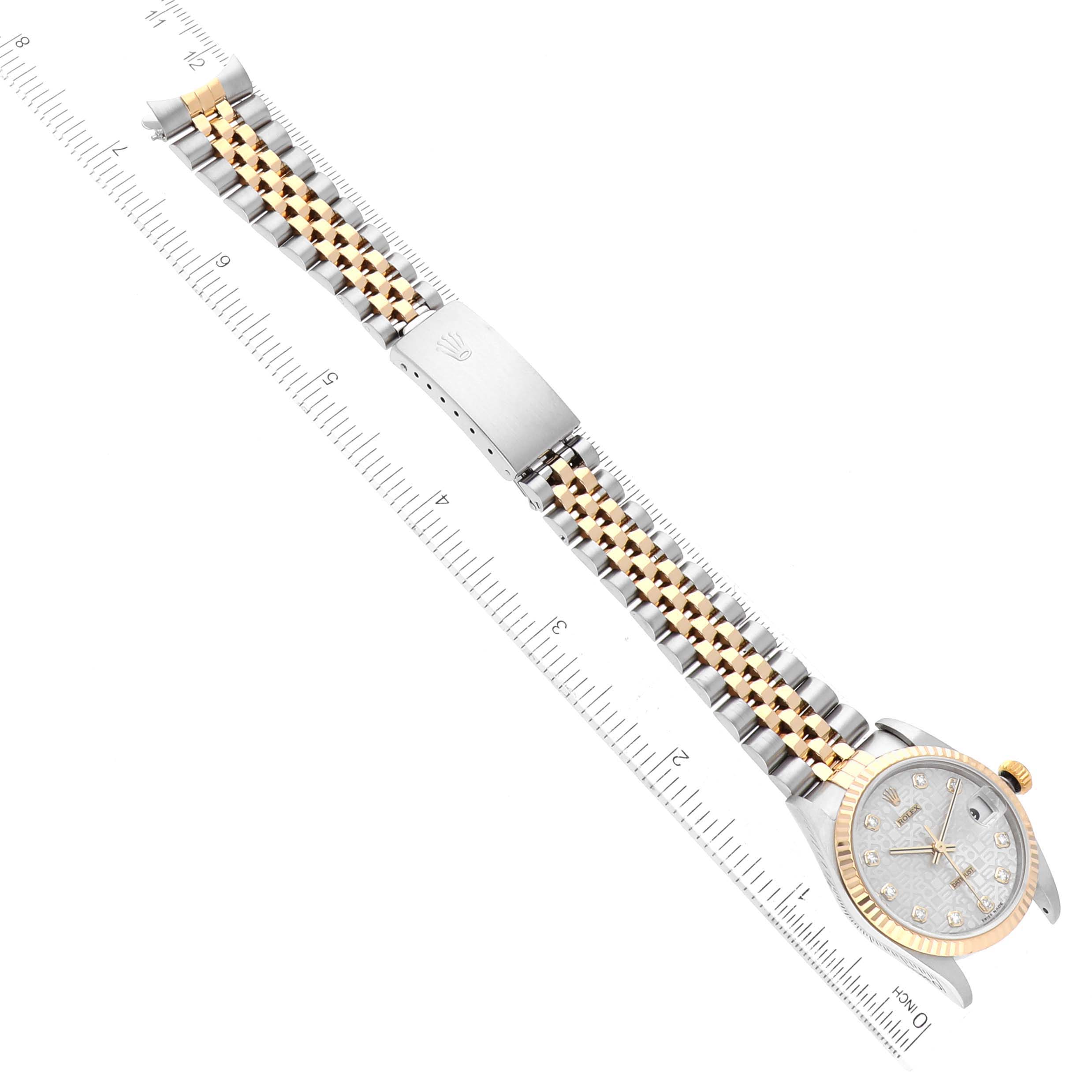 The image shows a top-down view of the Rolex Mid-Size 78273 Women
s Steel and Gold (two tone) Silver Dial 78273 Women
s Steel and Gold (two tone) Silver Dial watch, including the dial, bezel, and bracelet with the clasp open next to a ruler.