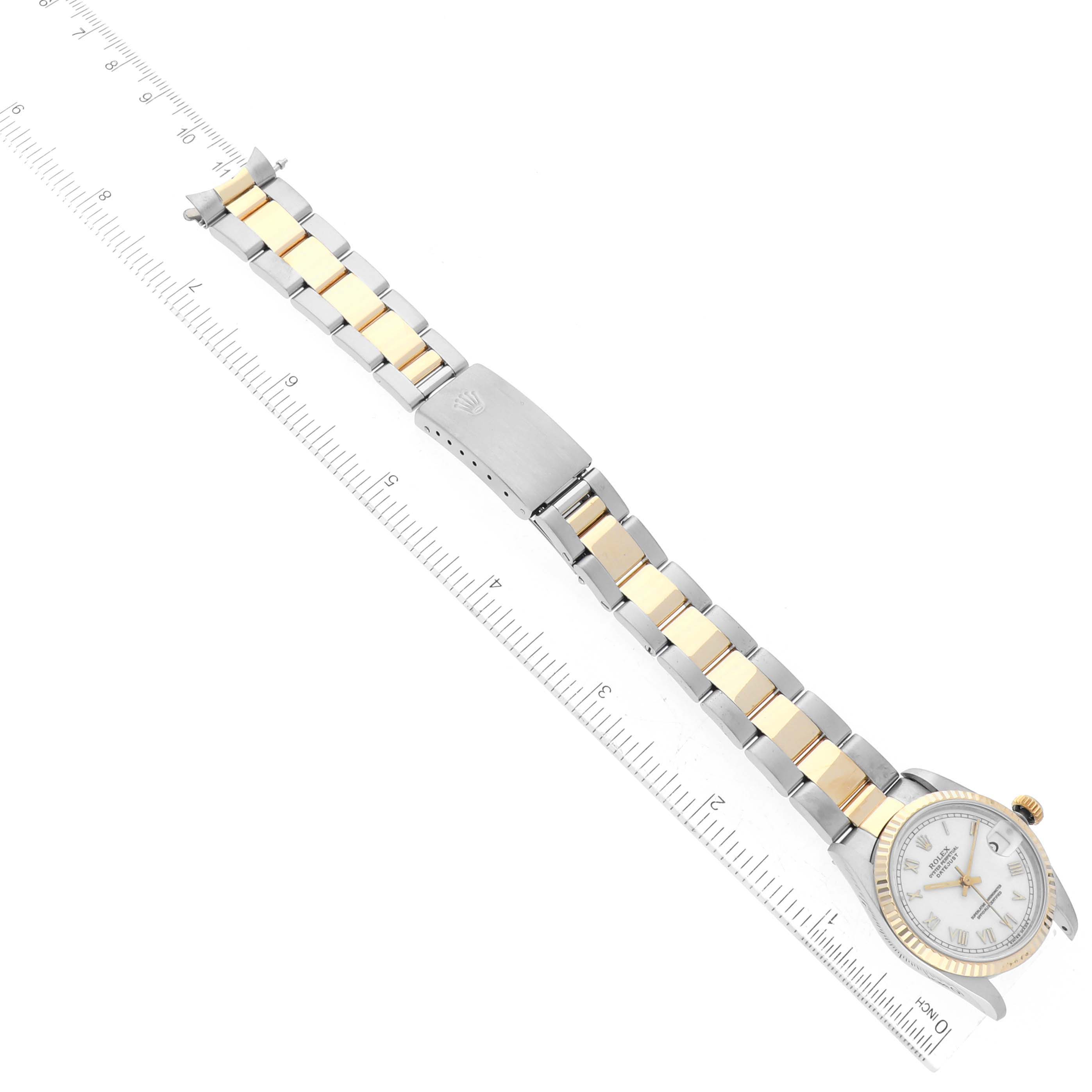 This image shows a Rolex Mid-Size 68273 Women's Steel and Gold (two tone) White Dial 68273 Women's Steel and Gold (two tone) White Dial model watch laid flat alongside a ruler, highlighting the watch face, bezel, and full bracelet.