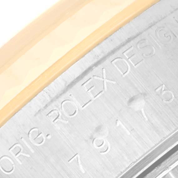 The image shows a close-up of the side of a Rolex Datejust 79173 Women's Steel and Gold (two tone) White Dial 79173 Women's Steel and Gold (two tone) White Dial, highlighting the engraved text on the edge.