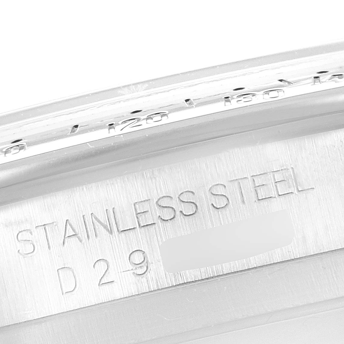 The image shows a close-up angle of the Rolex Daytona 116520 Men's Stainless Steel White Dial 116520 Men's Stainless Steel White Dial watch's stainless steel case with engraved text.