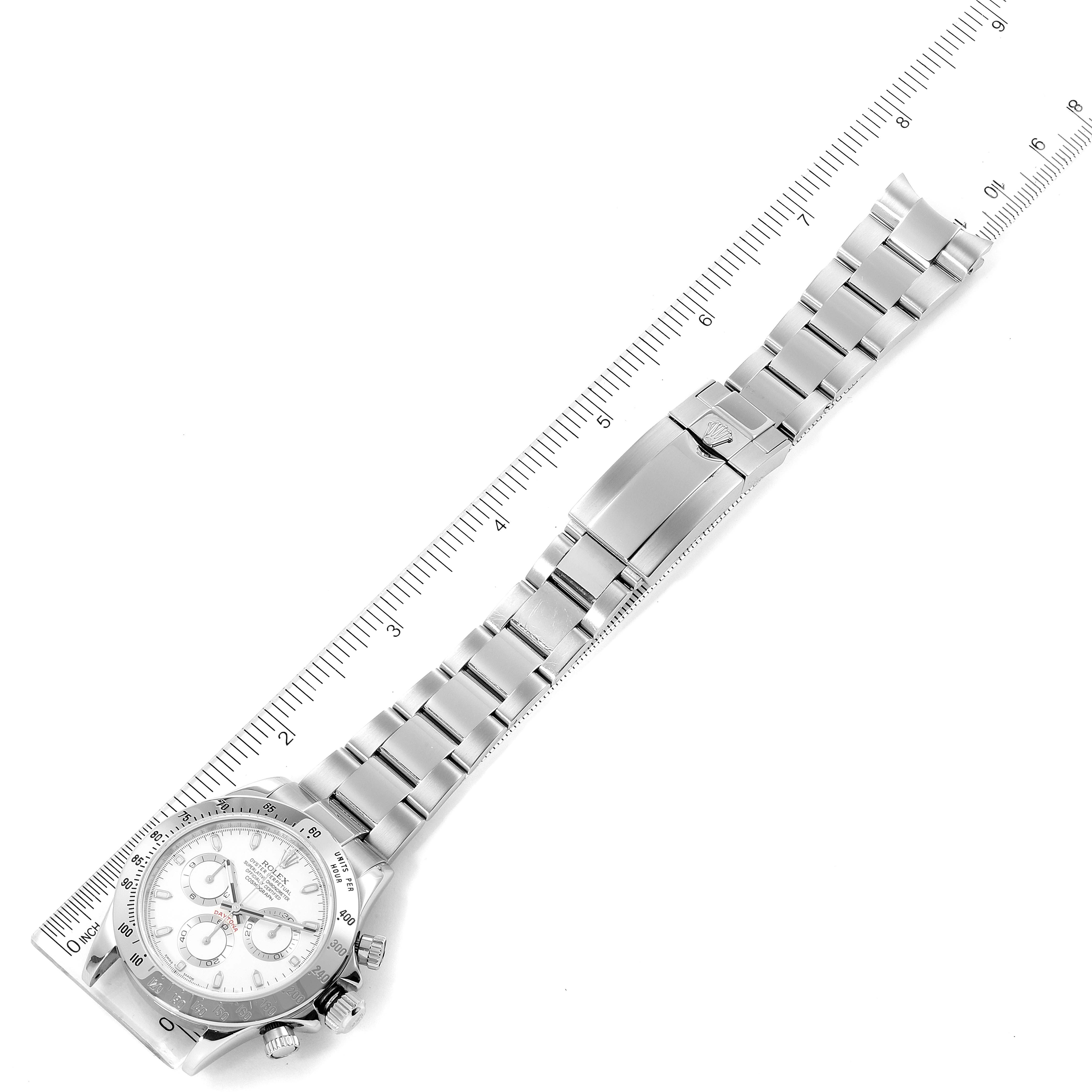 This image shows a top-down view of the Rolex Daytona 116520 Men's Stainless Steel White Dial 116520 Men's Stainless Steel White Dial with its full bracelet and clasp, aligned alongside a ruler.