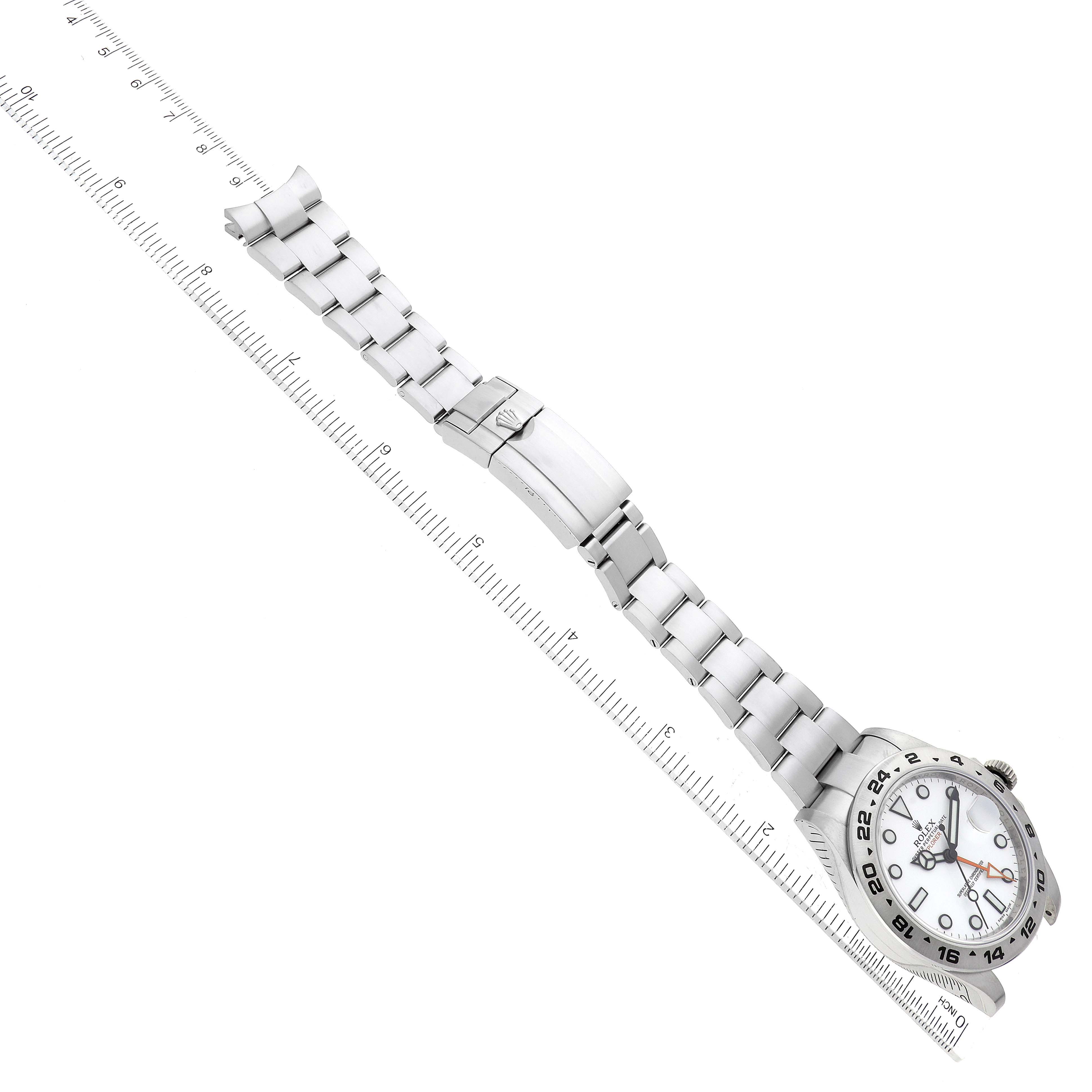 The image shows a Rolex Explorer 216570 Men's Stainless Steel White Dial 216570 Men's Stainless Steel White Dial watch laid flat with its entire bracelet and clasp visible alongside a ruler for scale.