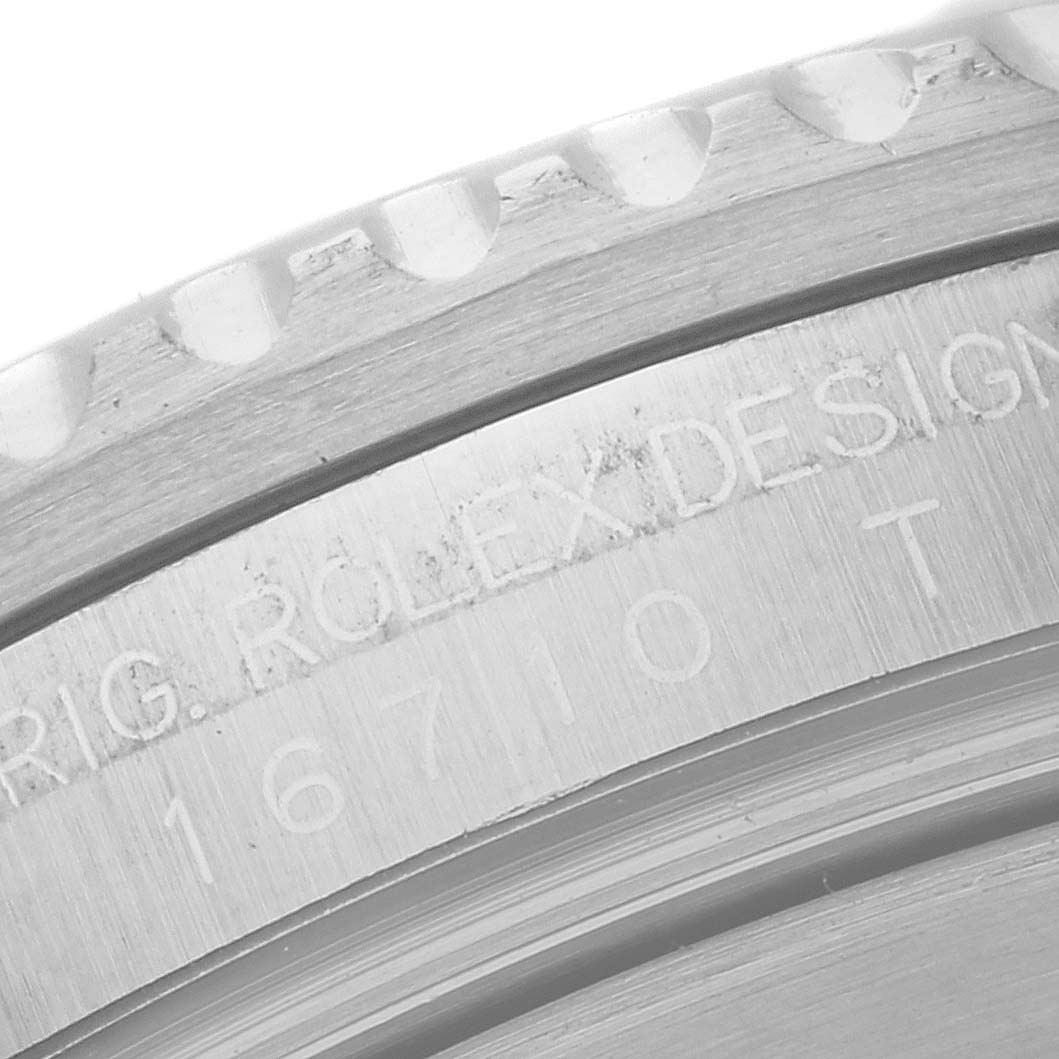 This is a close-up shot of the casing and engraved bezel of a Rolex GMT-Master 16710 Men's Stainless Steel Black Dial 16710 Men's Stainless Steel Black Dial watch.