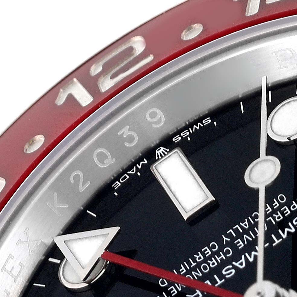The image showcases a close-up of the dial and bezel of the Rolex GMT-Master 126710BLRO Men
s Stainless Steel Black Dial 126710BLRO Men
s Stainless Steel Black Dial watch, highlighting the 12-hour mark and part of the hour markers.