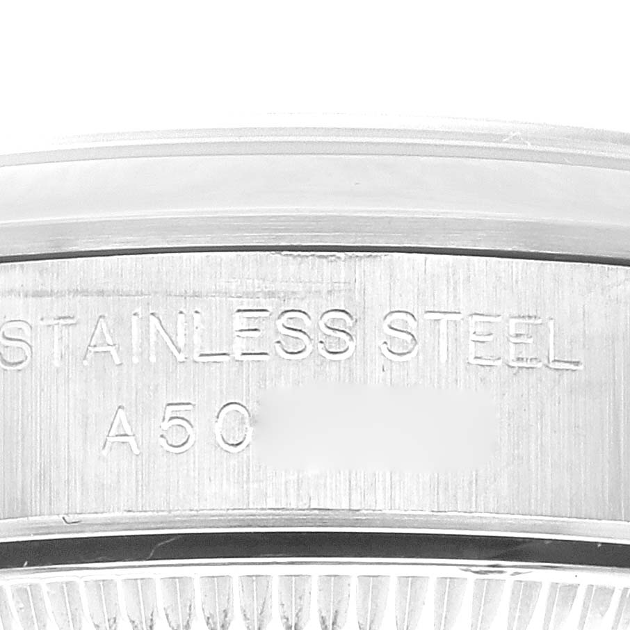 The image shows the edge of a stainless steel case with engravings from a Rolex Oyster Perpetual 76080 Women's Stainless Steel Blue Dial 76080 Women's Stainless Steel Blue Dial watch.