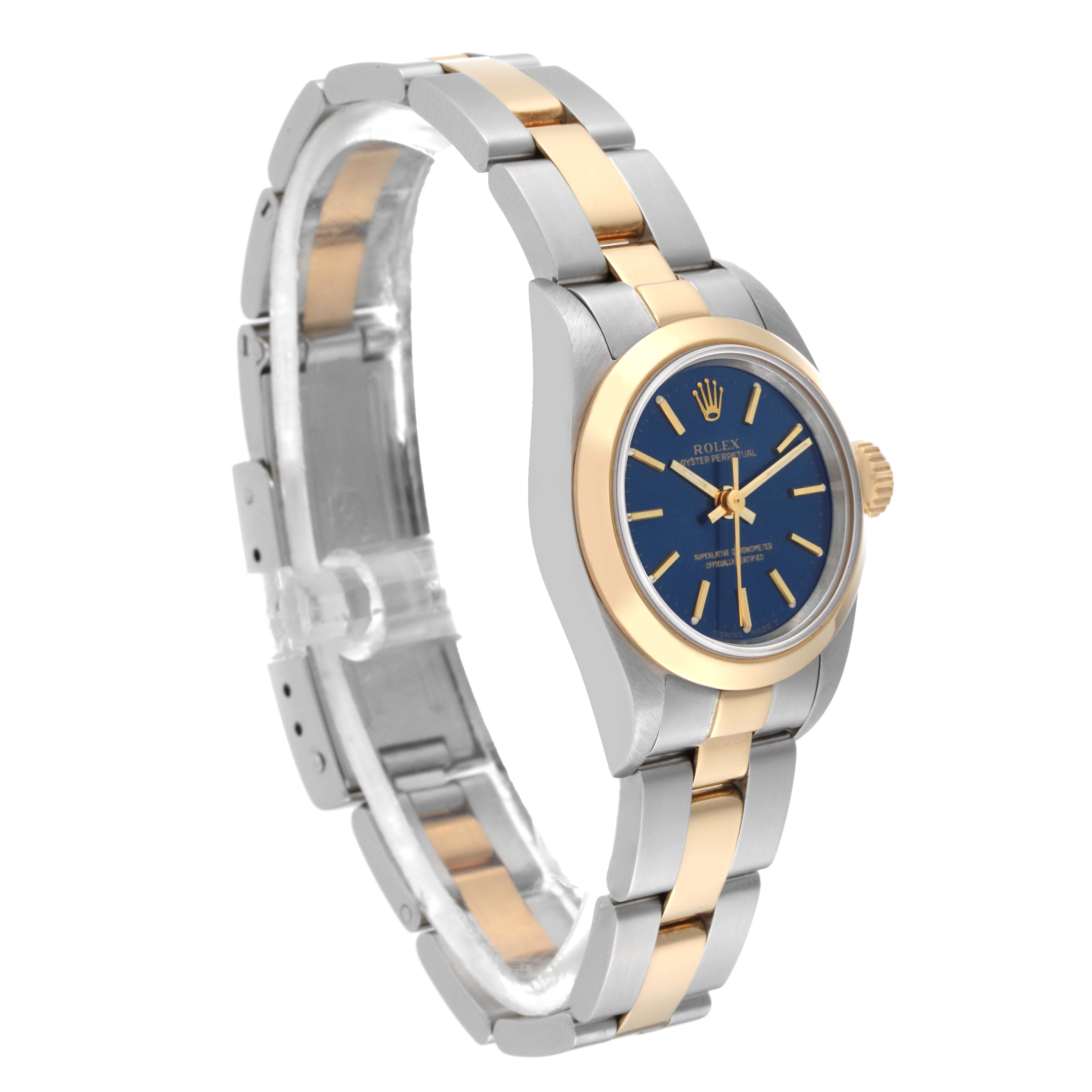 The image shows a side view of a Rolex Oyster Perpetual 67183 Women's Steel and Gold (two tone) Blue Dial 67183 Women's Steel and Gold (two tone) Blue Dial watch, highlighting its two-tone bracelet, blue dial, and gold bezel.