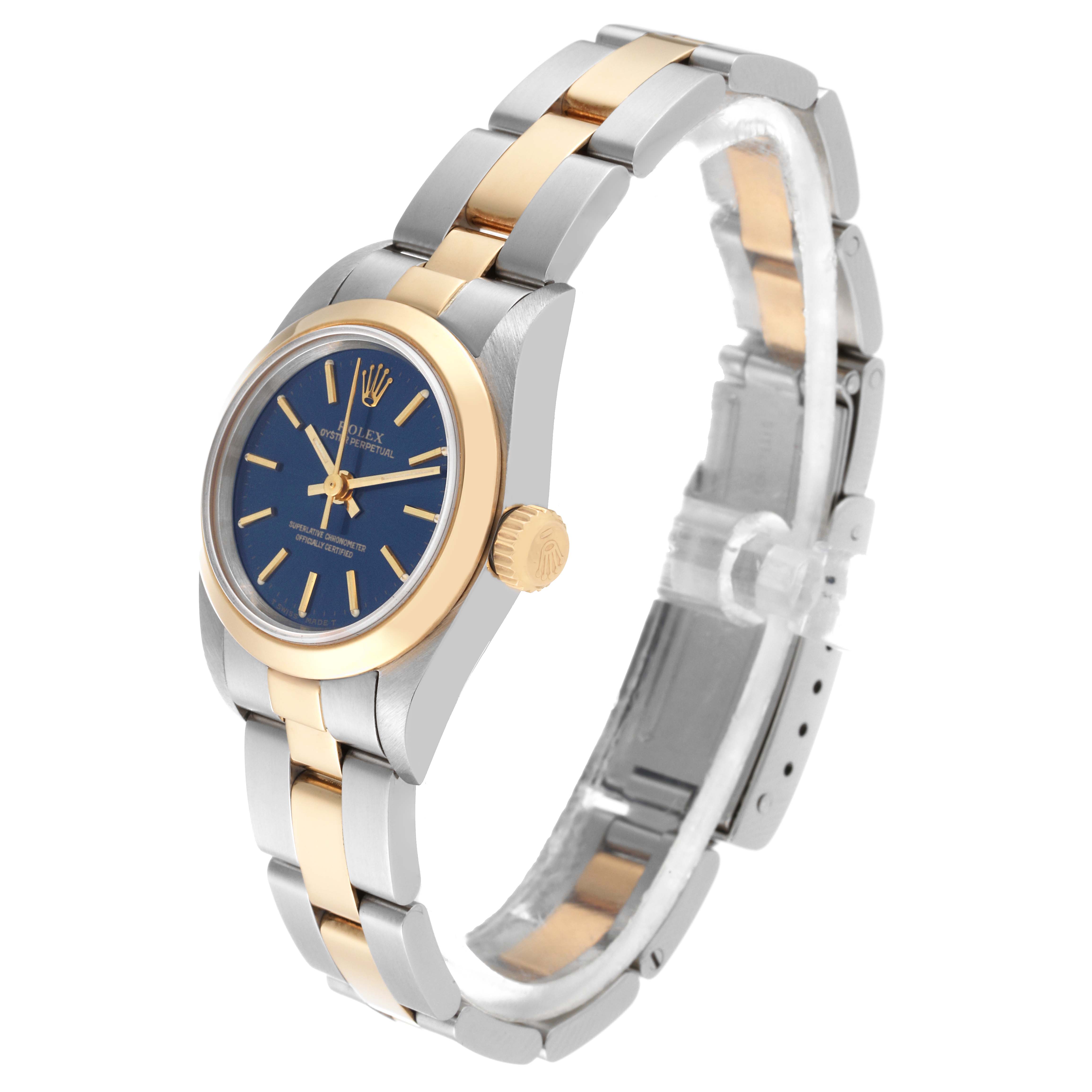 The Rolex Oyster Perpetual 67183 Women's Steel and Gold (two tone) Blue Dial 67183 Women's Steel and Gold (two tone) Blue Dial watch is shown at an angled side view, displaying its blue dial, gold crown, and two-tone bracelet.