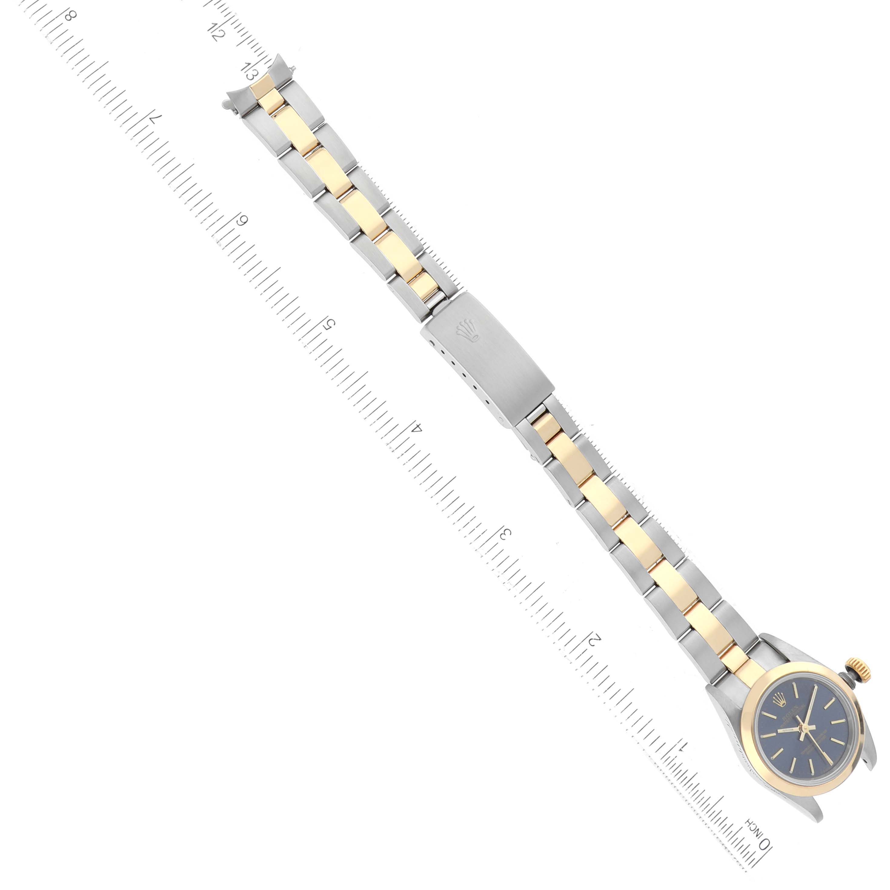 The image shows a Rolex Oyster Perpetual 67183 Women's Steel and Gold (two tone) Blue Dial 67183 Women's Steel and Gold (two tone) Blue Dial watch, focusing on the band and partially on the watch face at an overhead angle.