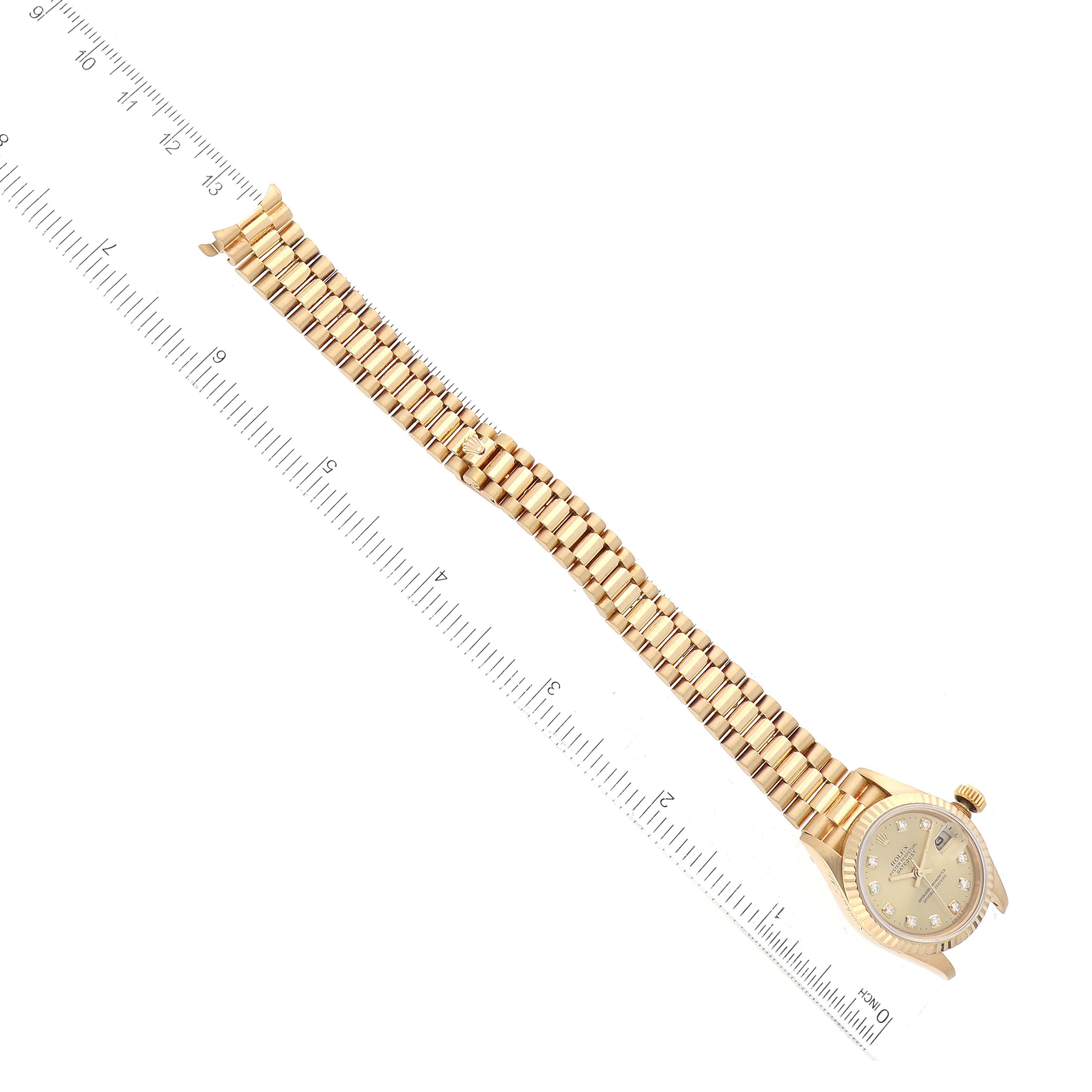 This image shows a top-down view of a Rolex President 79178 Women
s Yellow Gold Champagne Dial 79178 Women
s Yellow Gold Champagne Dial model watch, displaying its full length alongside a ruler.