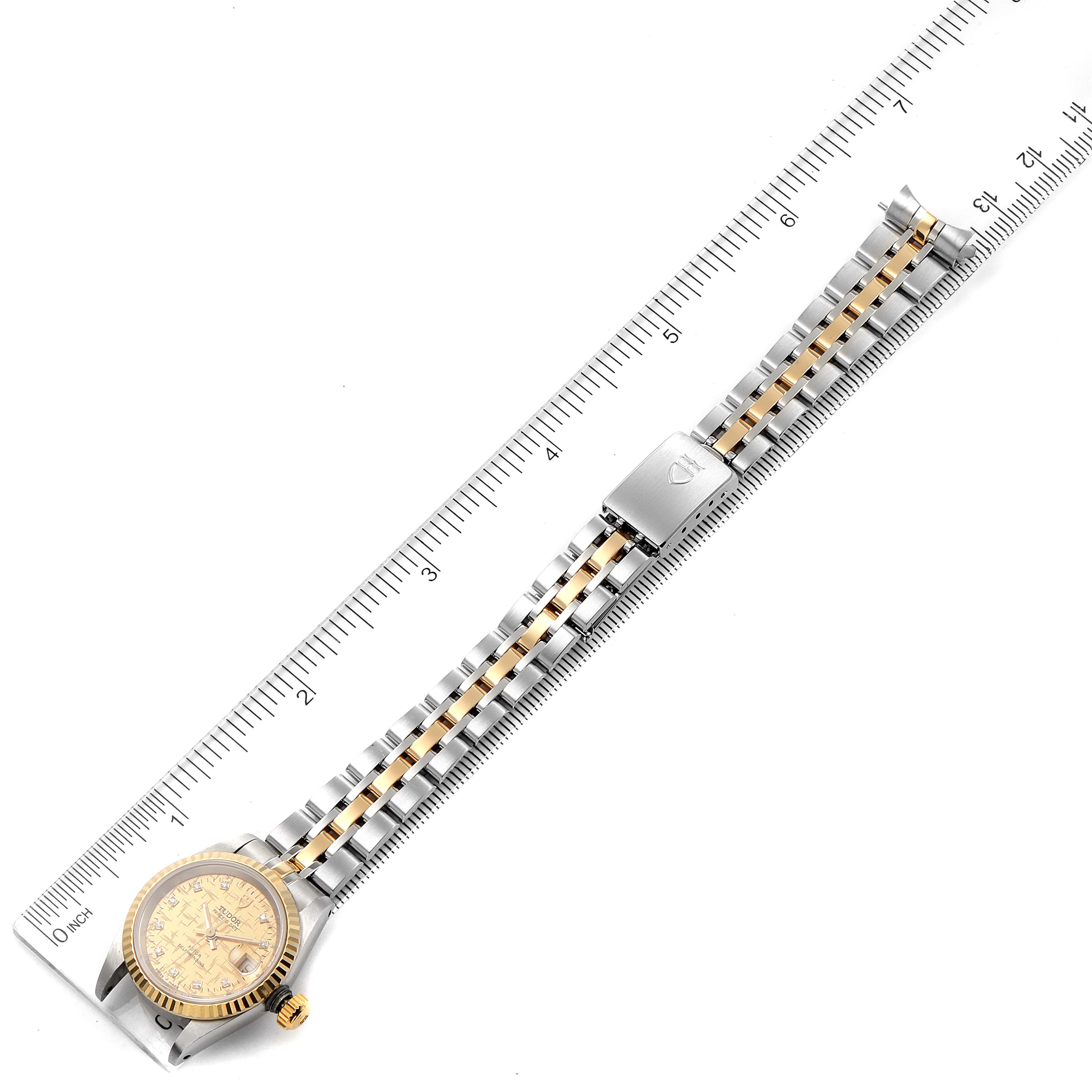 The image shows a Tudor Princess 92413 Women's Steel and Gold (two tone) Champagne Dial 92413 Women's Steel and Gold (two tone) Champagne Dial model watch laid flat alongside a ruler, highlighting its bracelet and dial.