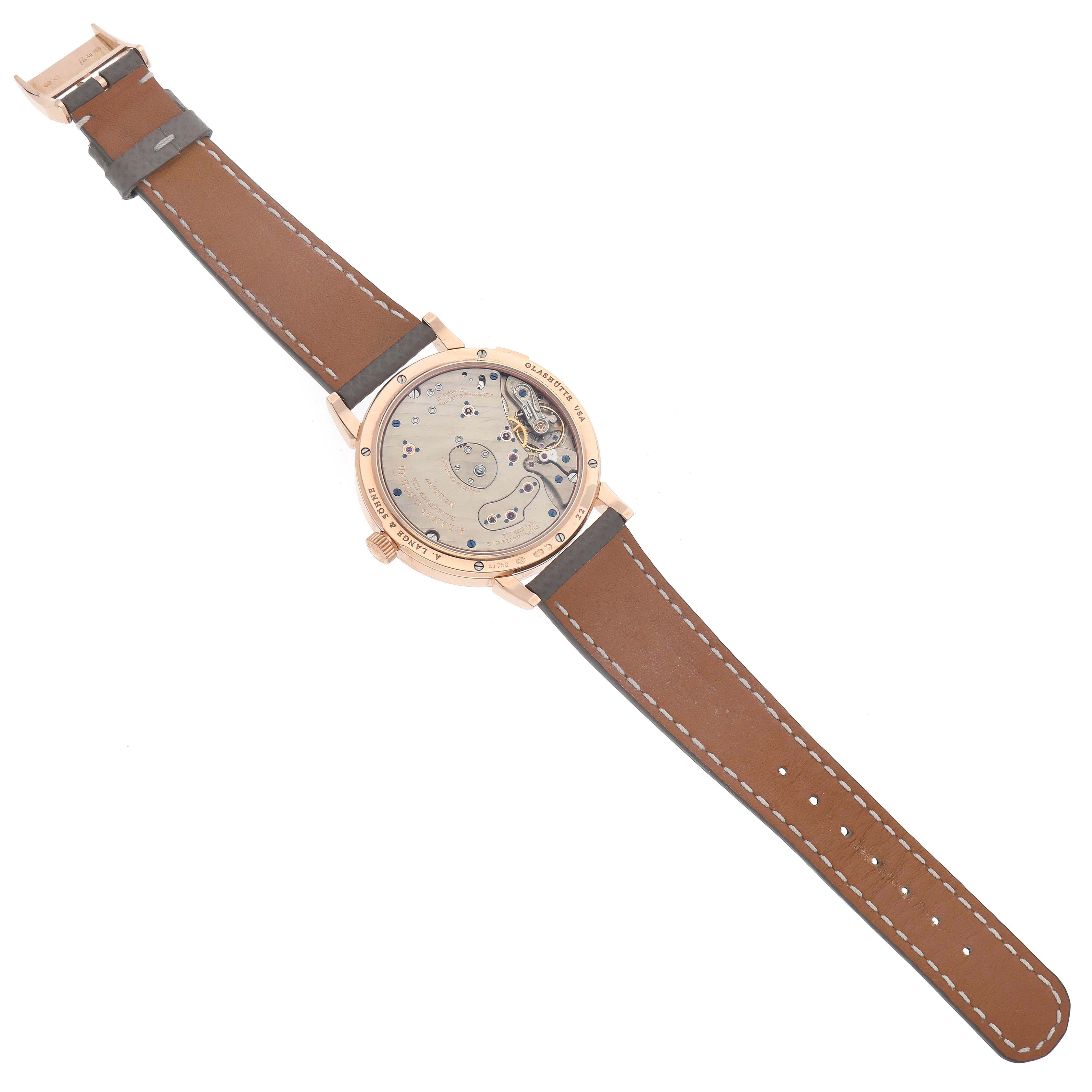 The image shows the back view of an A. Lange & Sohne Lange 1 139.032 Men's Rose Gold Silver Dial watch, highlighting its movement and leather strap.