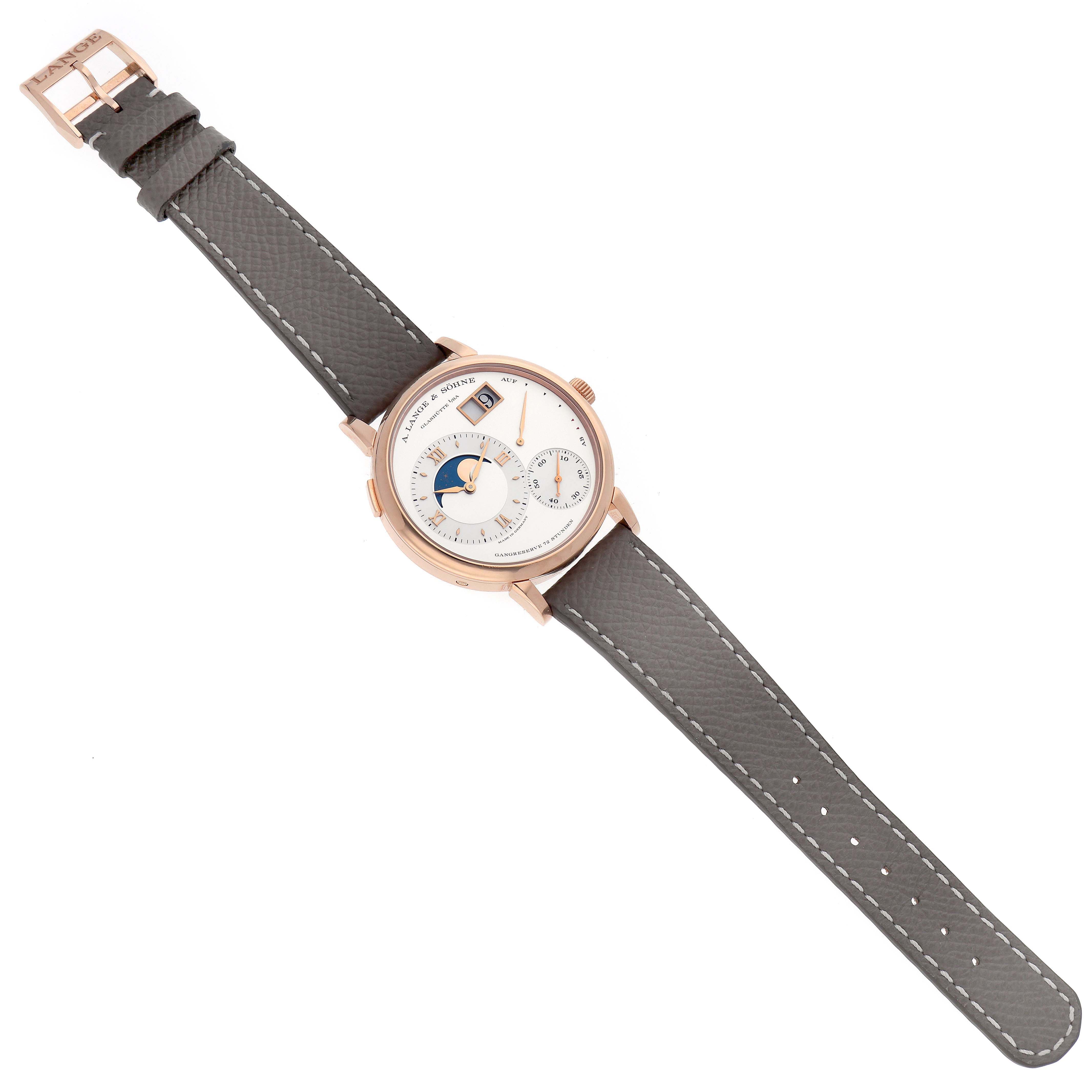 The A. Lange & Sohne Lange 1 139.032 Men's Rose Gold Silver Dial watch is shown from a top-down angle, highlighting the dial, case, and leather strap.