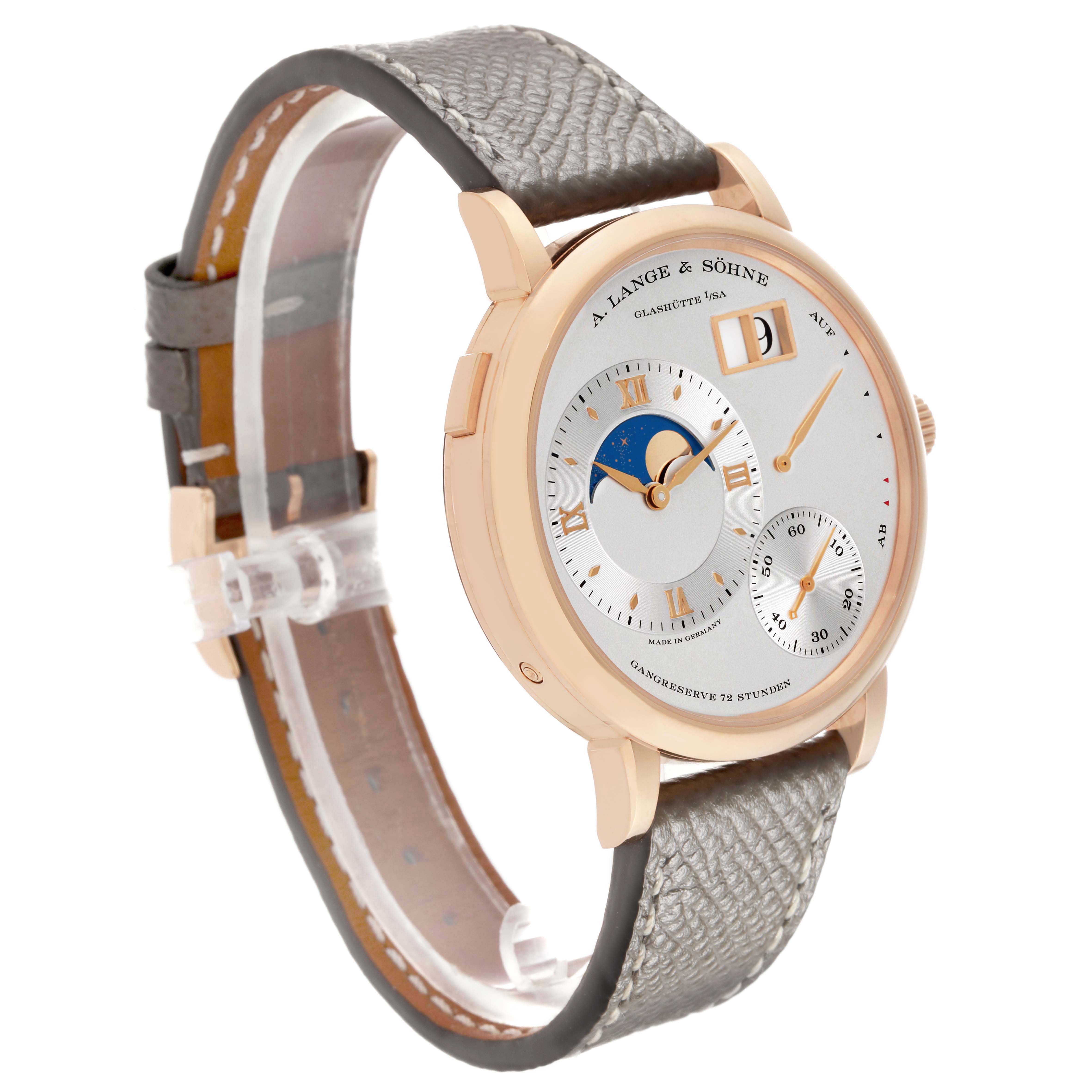 The Lange 1 by A. Lange & Söhne is shown at an angle displaying the dial, moon phase, sub-dials, and leather strap.