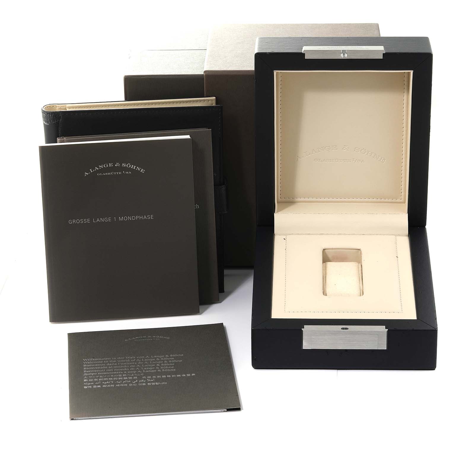 The image shows the packaging and manuals for the Lange 1 model by A. Lange 
Sohne, including the watch box and booklets.