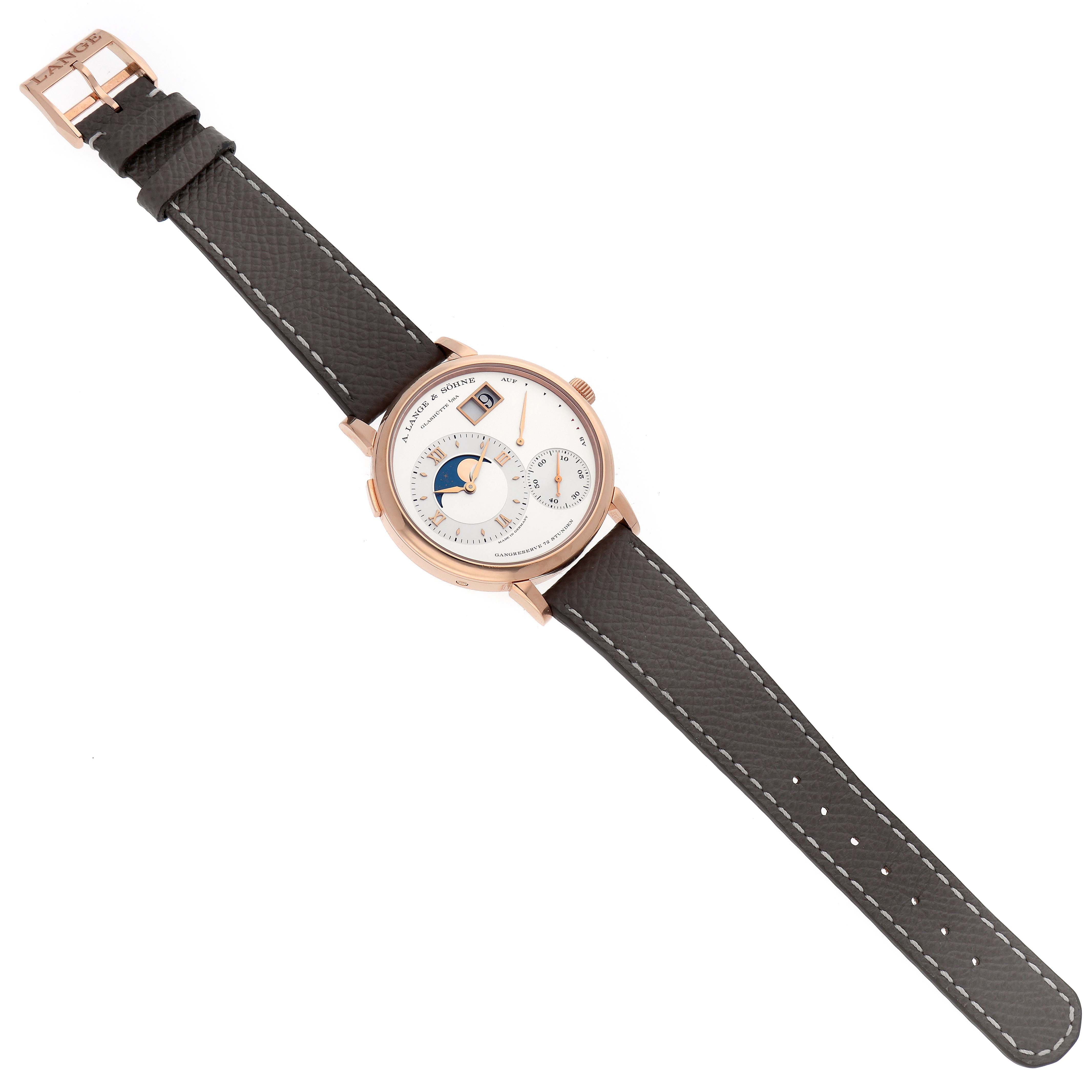 The A. Lange 
Sohne Lange 1 139.032 Men
s Rose Gold Silver Dial watch is shown from a top-down angle, displaying the face, straps, and buckle.