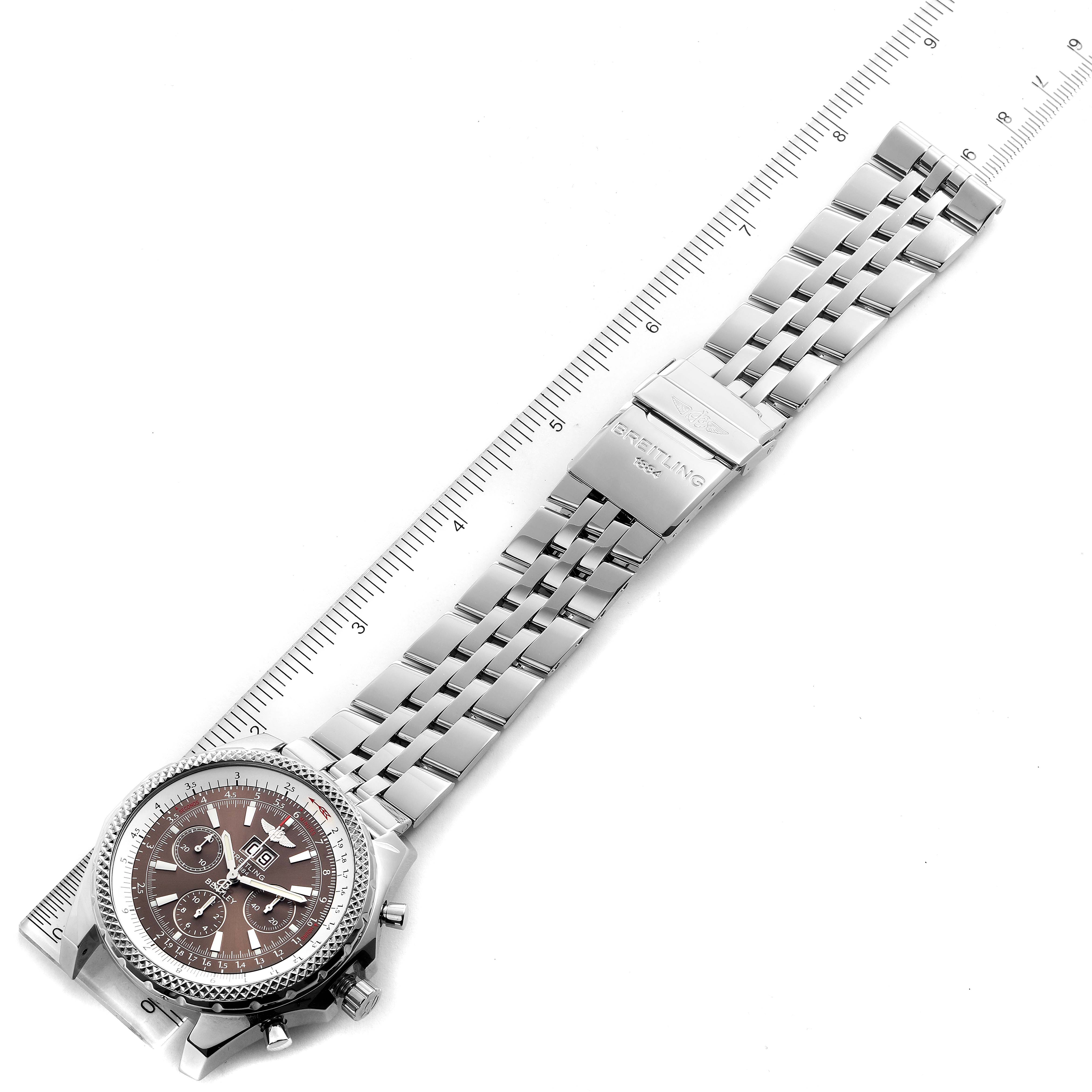 The Bentley model by Breitling is shown lying flat with its full metal bracelet extended and a ruler beside it for measurement.
