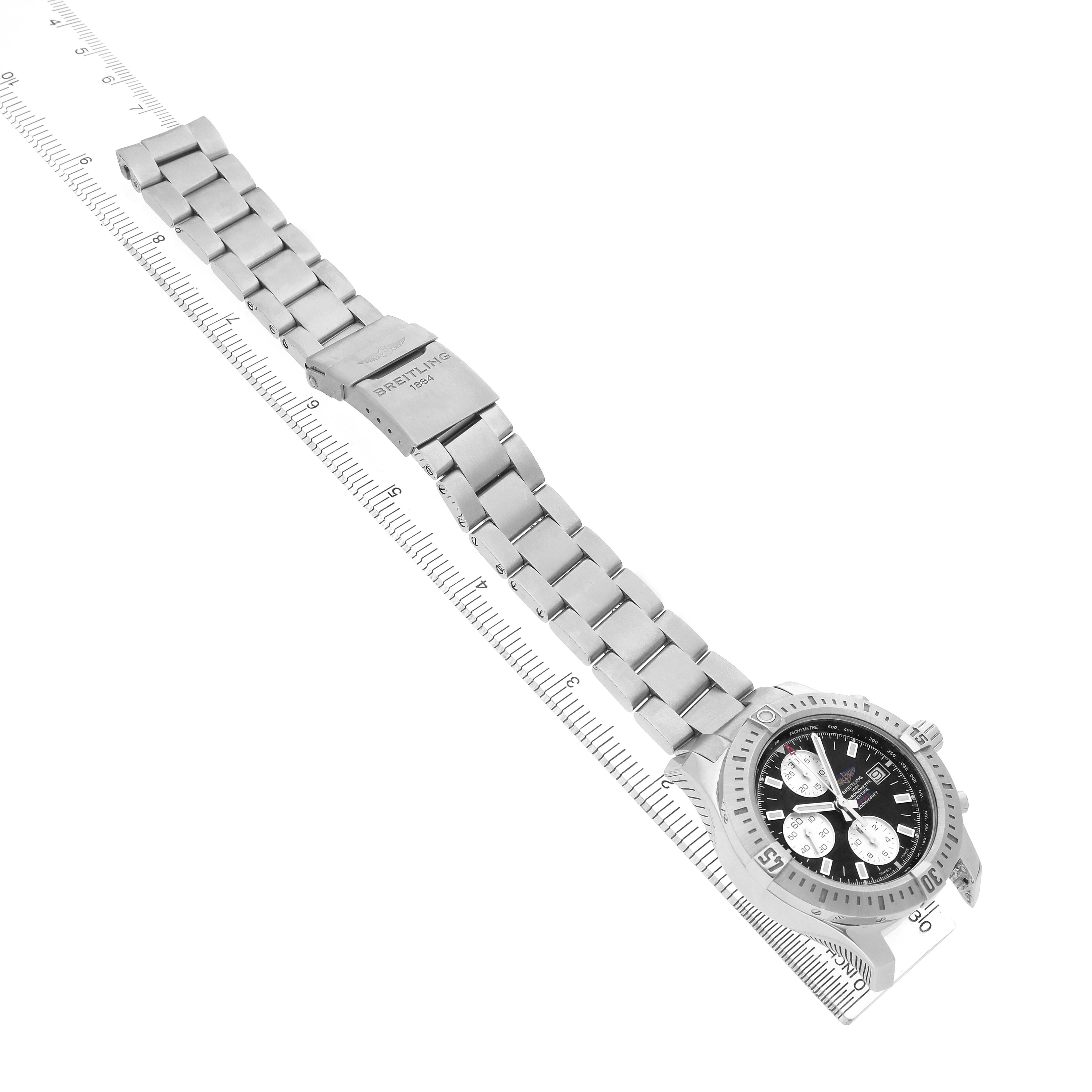 The Breitling Colt A1338811/BD83 Men's Stainless Steel Black Dial watch is shown at an angle displaying the face, bezel, bracelet, and clasp, with a ruler for scale.