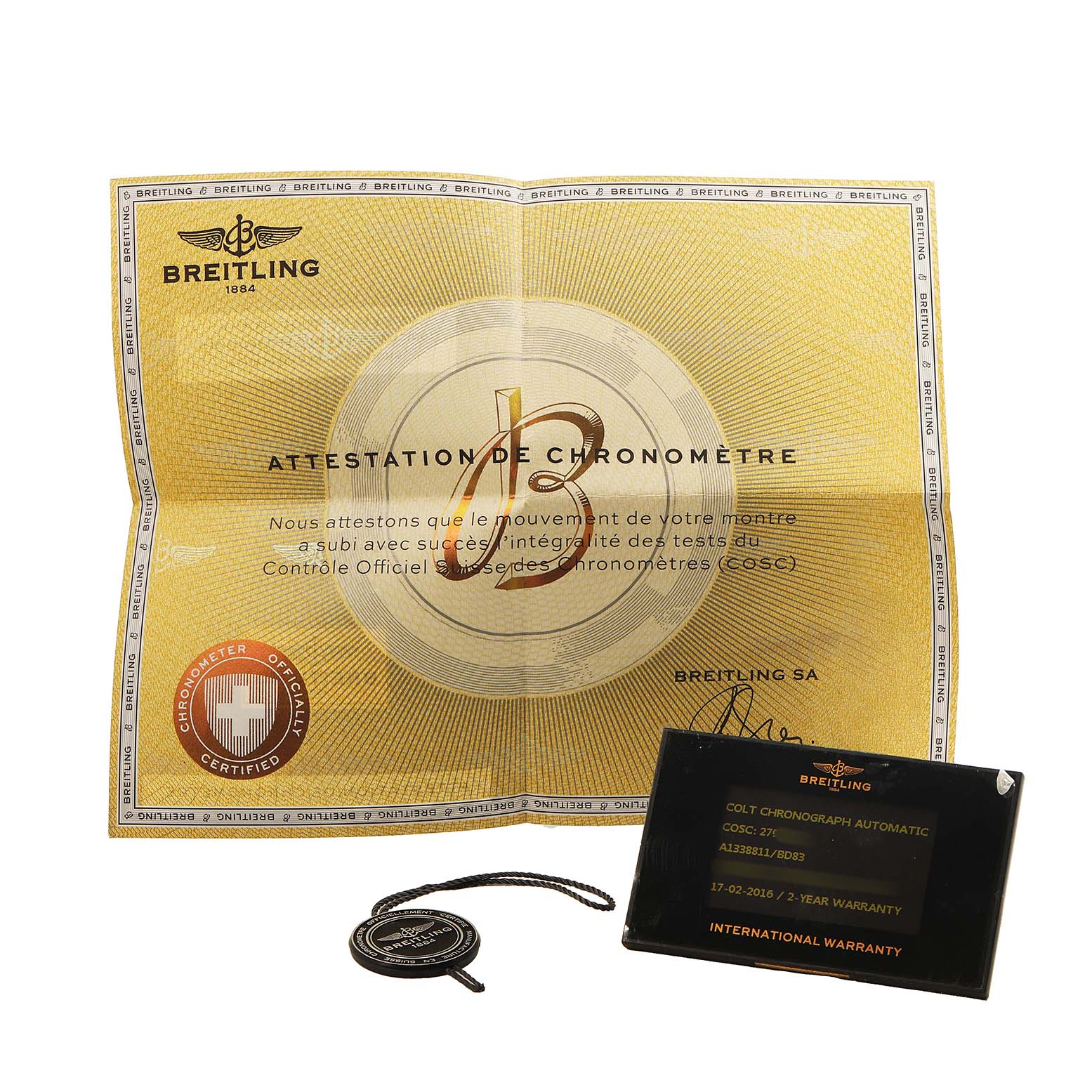The image shows a Breitling Colt A1338811/BD83 Men's Stainless Steel Black Dial model's warranty card, certificate, and a tag from a top view.