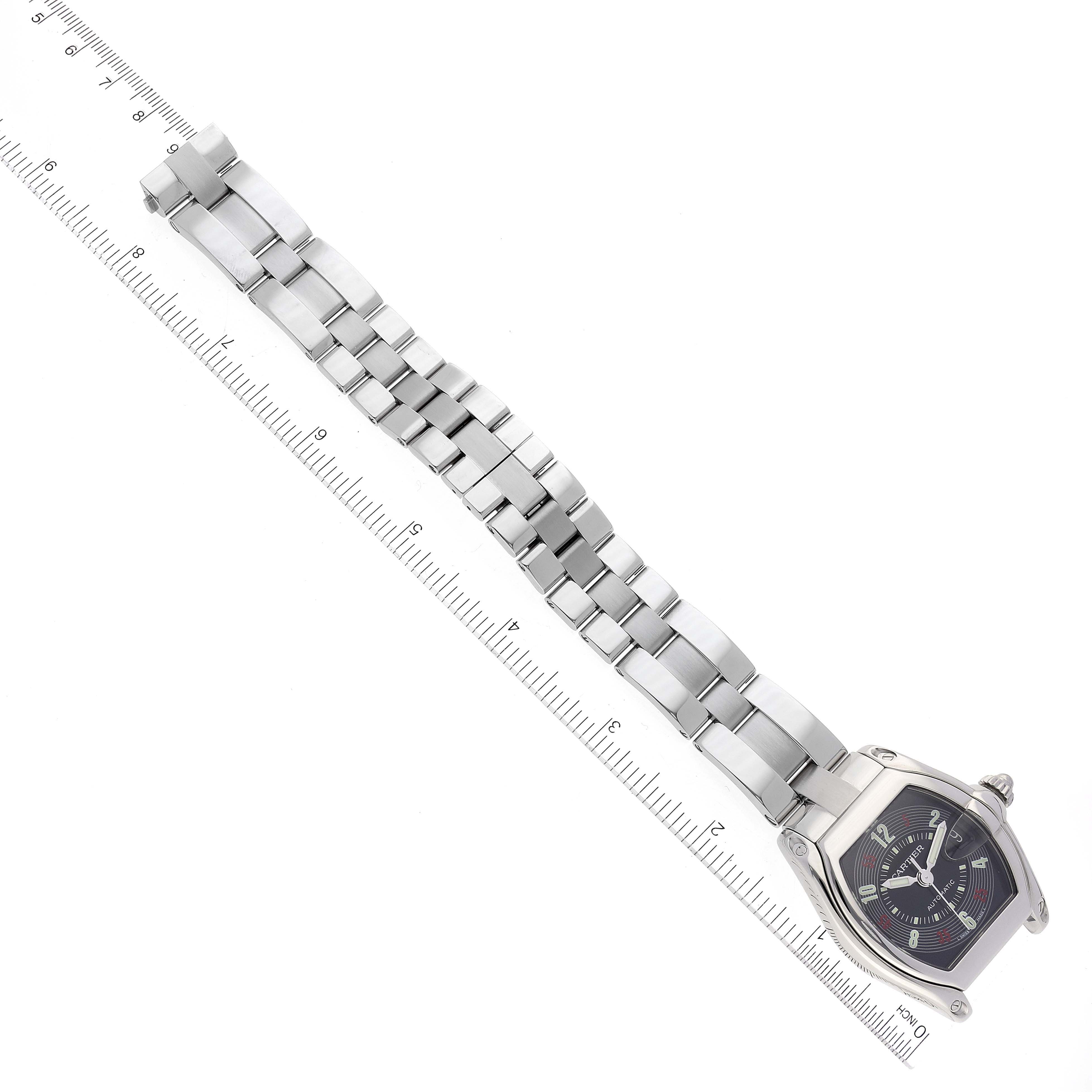 The image shows a Cartier Roadster W62002V3 Men's Stainless Steel Black Dial W62002V3 Men's Stainless Steel Black Dial watch from a top-down angle, displaying its entire metal bracelet and face alongside a ruler for scale.