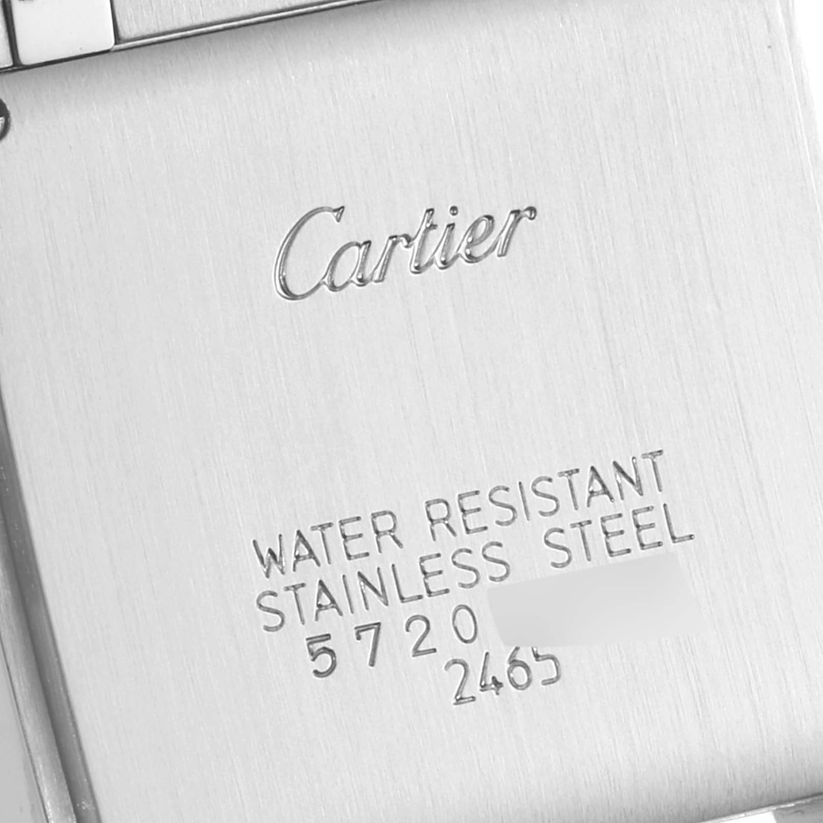 This image shows the engraved back of the Cartier Tank Française watch, displaying the brand, model, and material information.