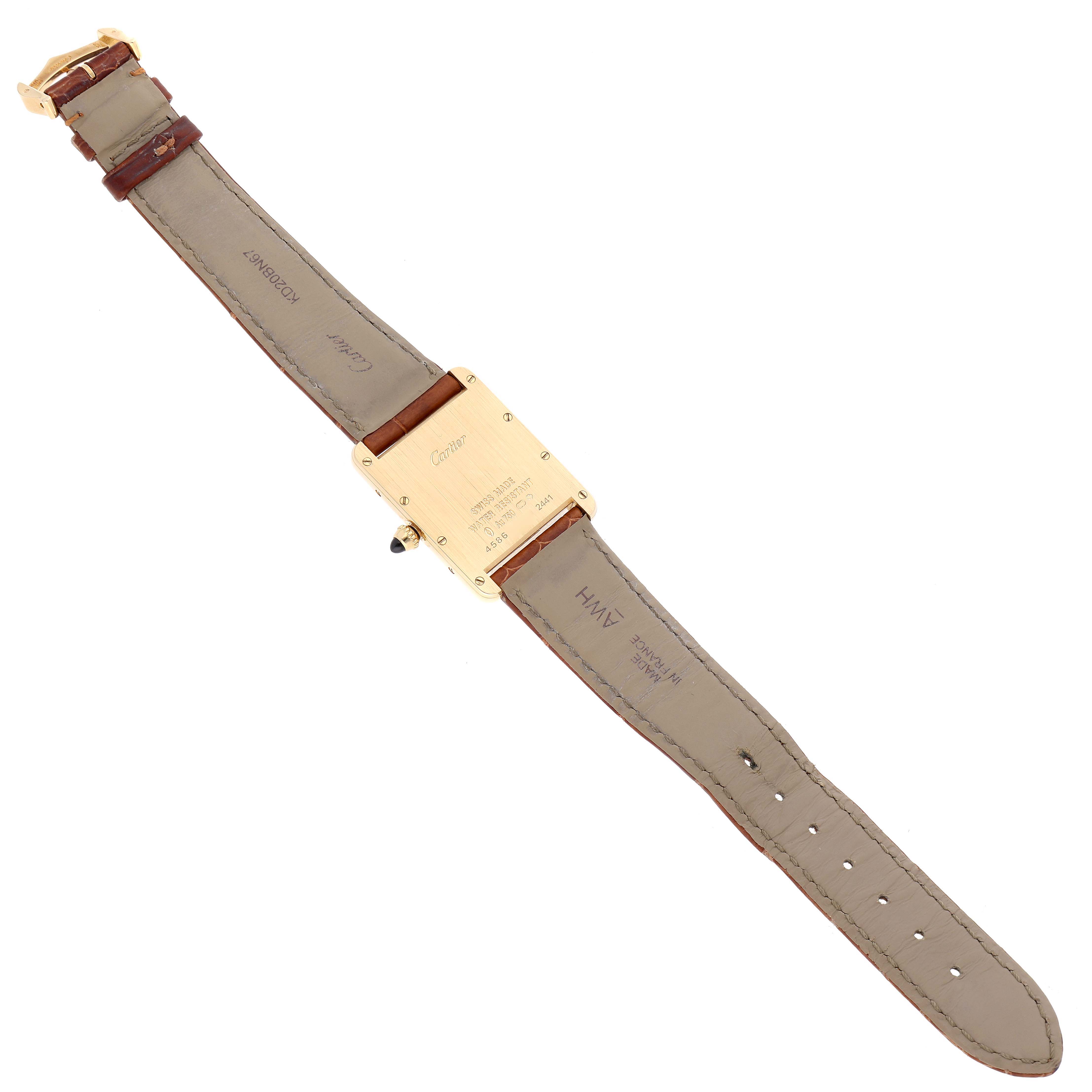 The image shows the back of a Tank Louis Cartier watch, highlighting the leather strap and the back plate with inscriptions.