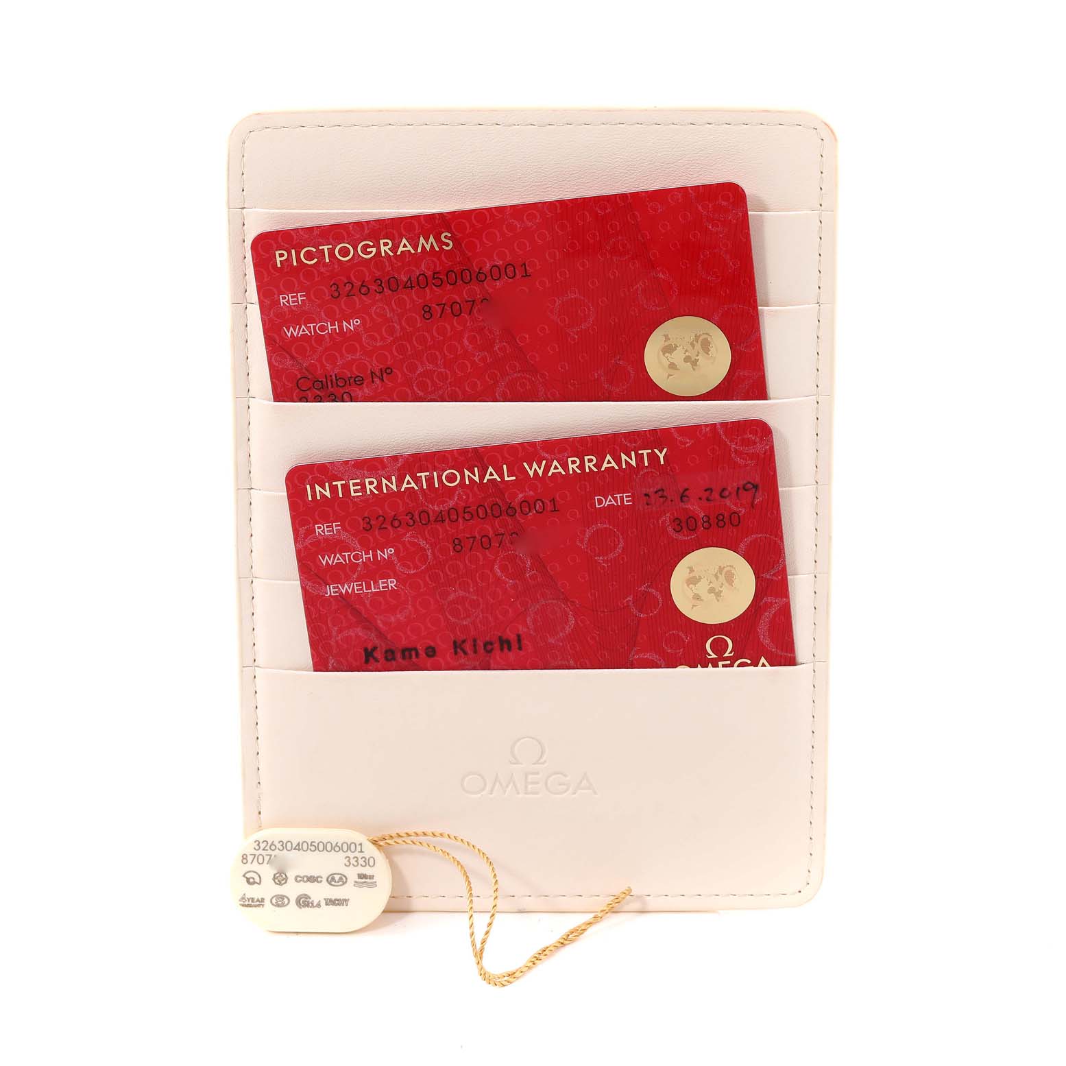 This image shows the warranty cards and tags for the Omega Speedmaster 326.30.40.50.06.001 Men's Stainless Steel Grey Dial 326.30.40.50.06.001 Men's Stainless Steel Grey Dial, displayed in a white holder.