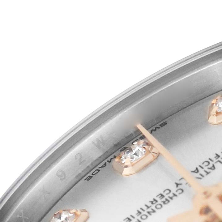 The image shows a close-up of a Rolex Mid-Size M278341RBR-0016 Women's Steel and Gold (two tone) Silver Dial watch face, highlighting the bezel, diamond hour markers, and watch hands.