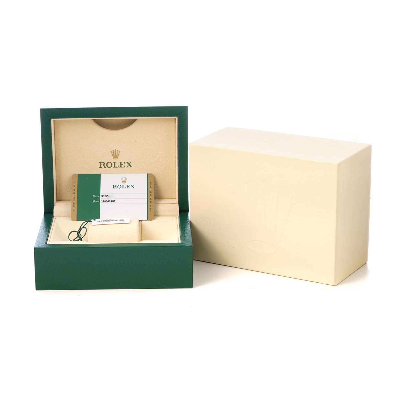 The image shows an open Rolex box with warranty cards and a tag, viewed from the front.