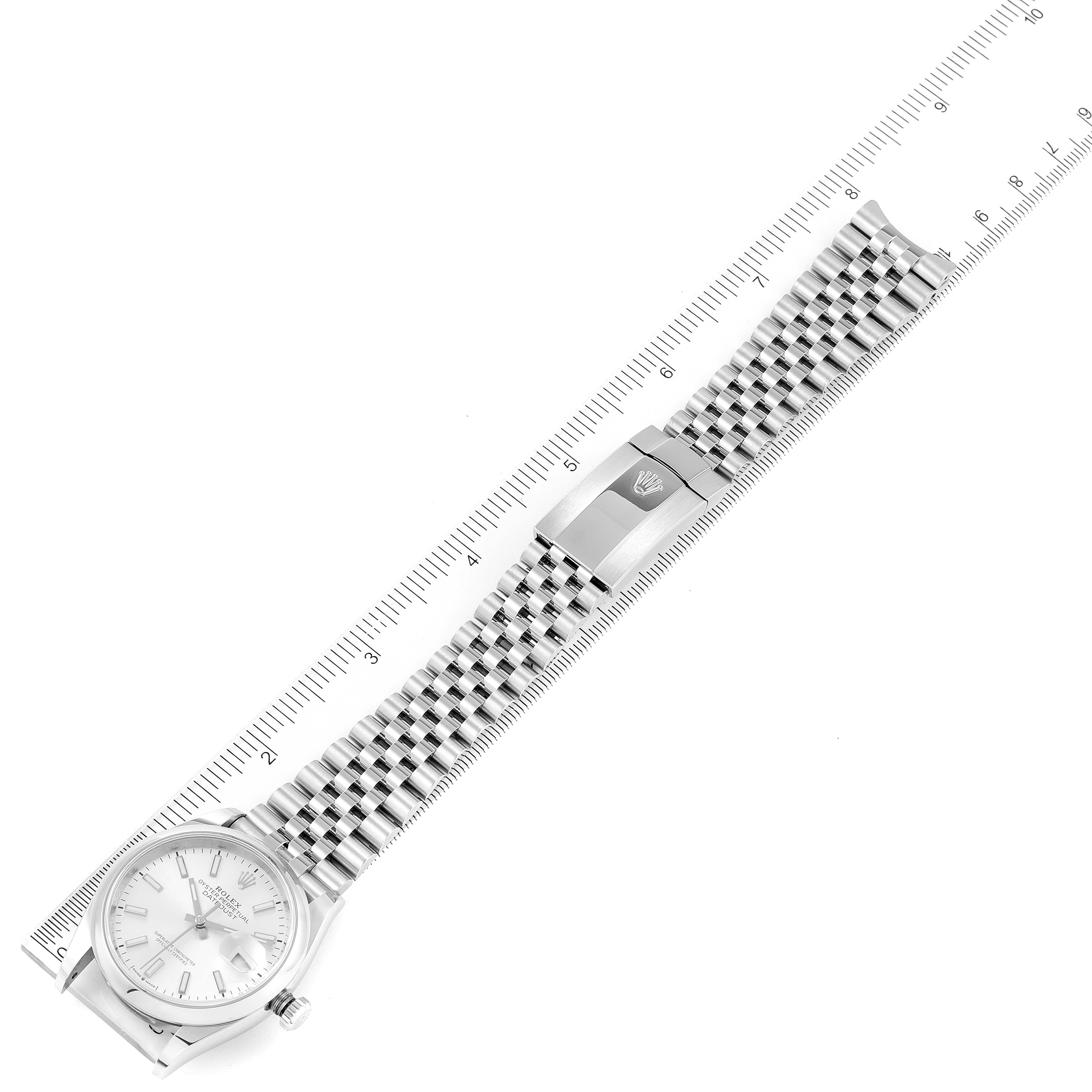 The image shows a Rolex Datejust 126200 Men's Stainless Steel Silver Dial 126200 Men's Stainless Steel Silver Dial watch laying flat, displaying its face, bracelet, and clasp alongside a ruler for size reference.