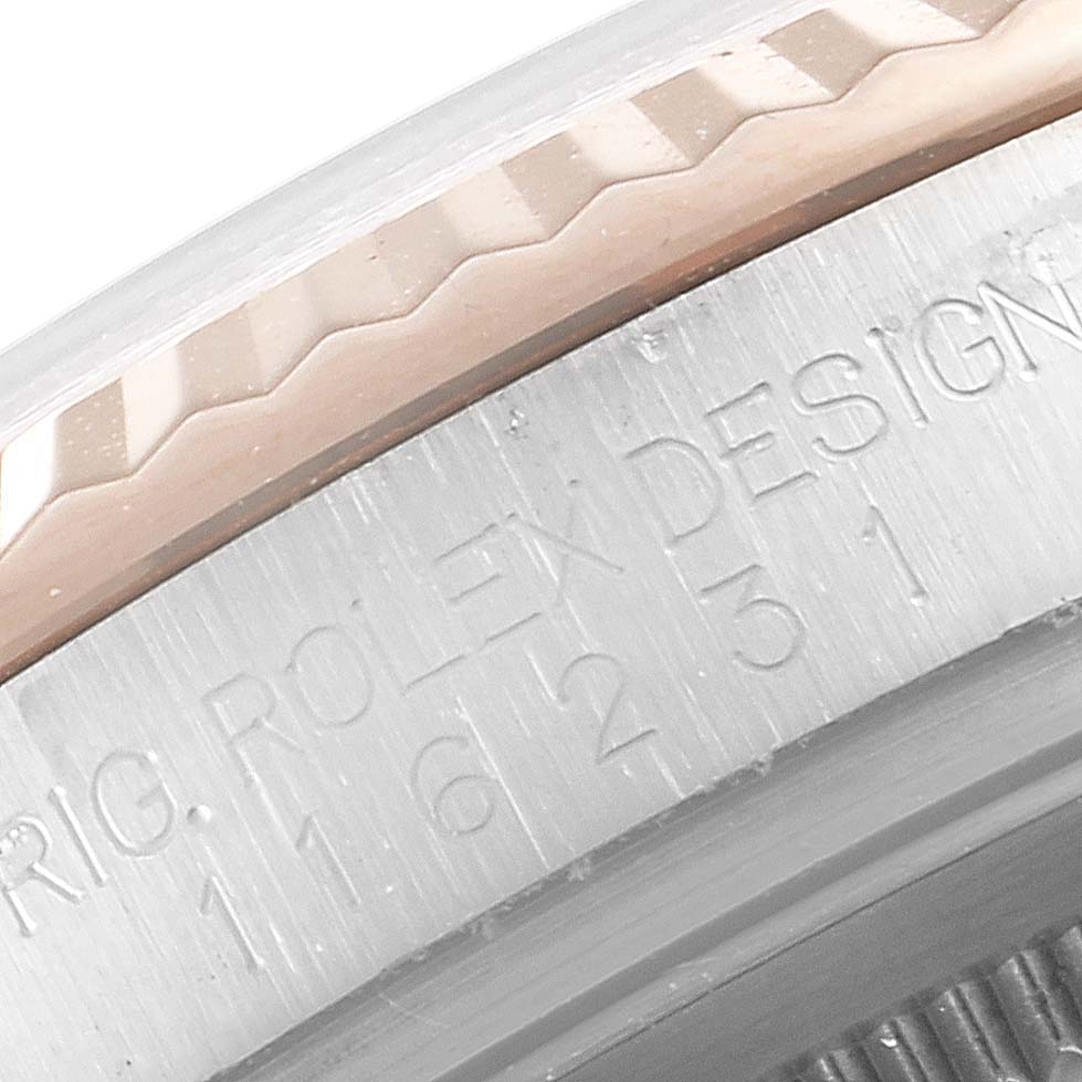 The image shows a close-up of the side of the bezel and case of a Rolex Datejust 116231 Men's Steel and Gold (two tone) Mother of Pearl Dial 116231 Men's Steel and Gold (two tone) Mother of Pearl Dial watch, revealing part of the serial number and fluted bezel design.