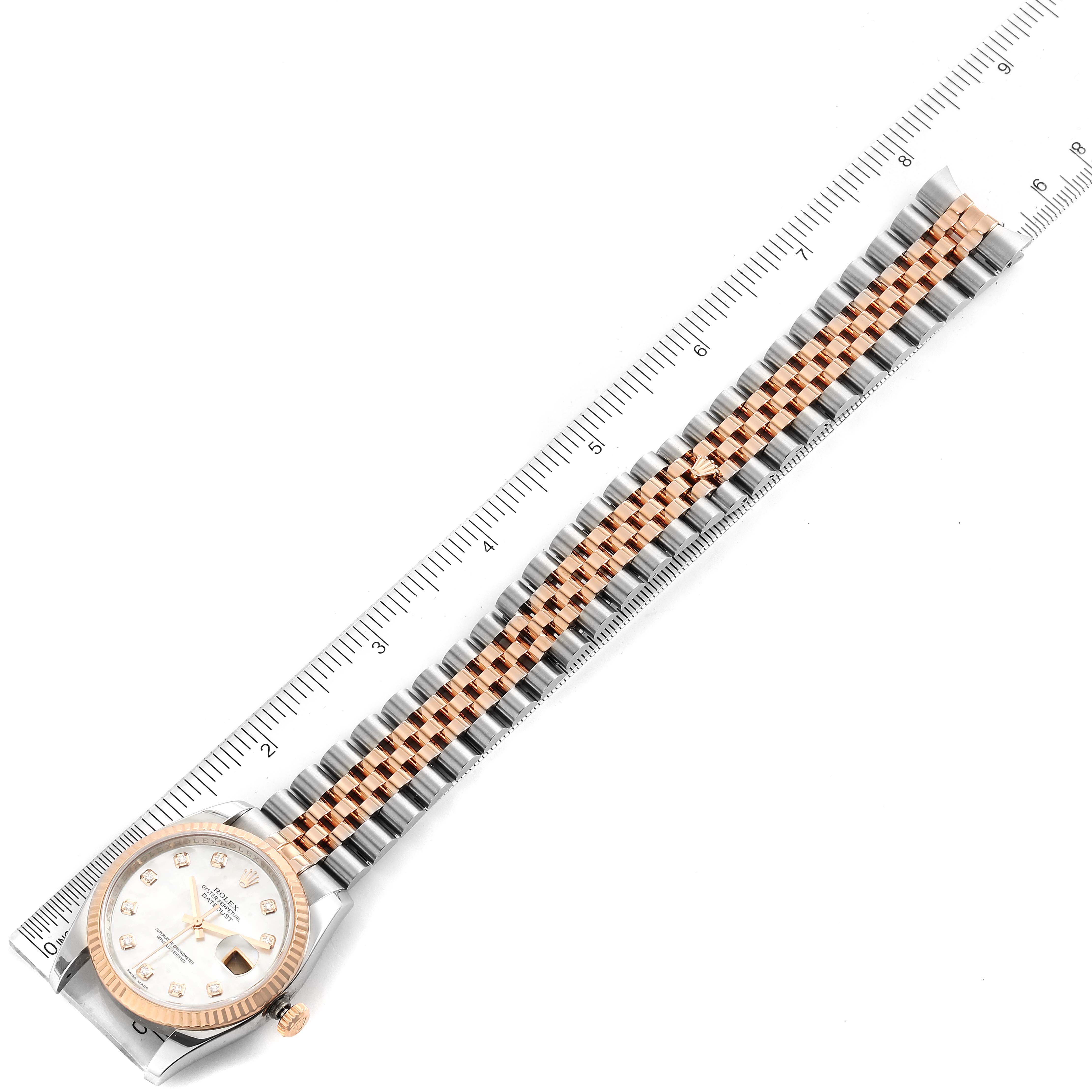 This image shows a top-down view of a Rolex Datejust 116231 Men's Steel and Gold (two tone) Mother of Pearl Dial 116231 Men's Steel and Gold (two tone) Mother of Pearl Dial, highlighting its face and two-tone bracelet alongside a ruler for scale.