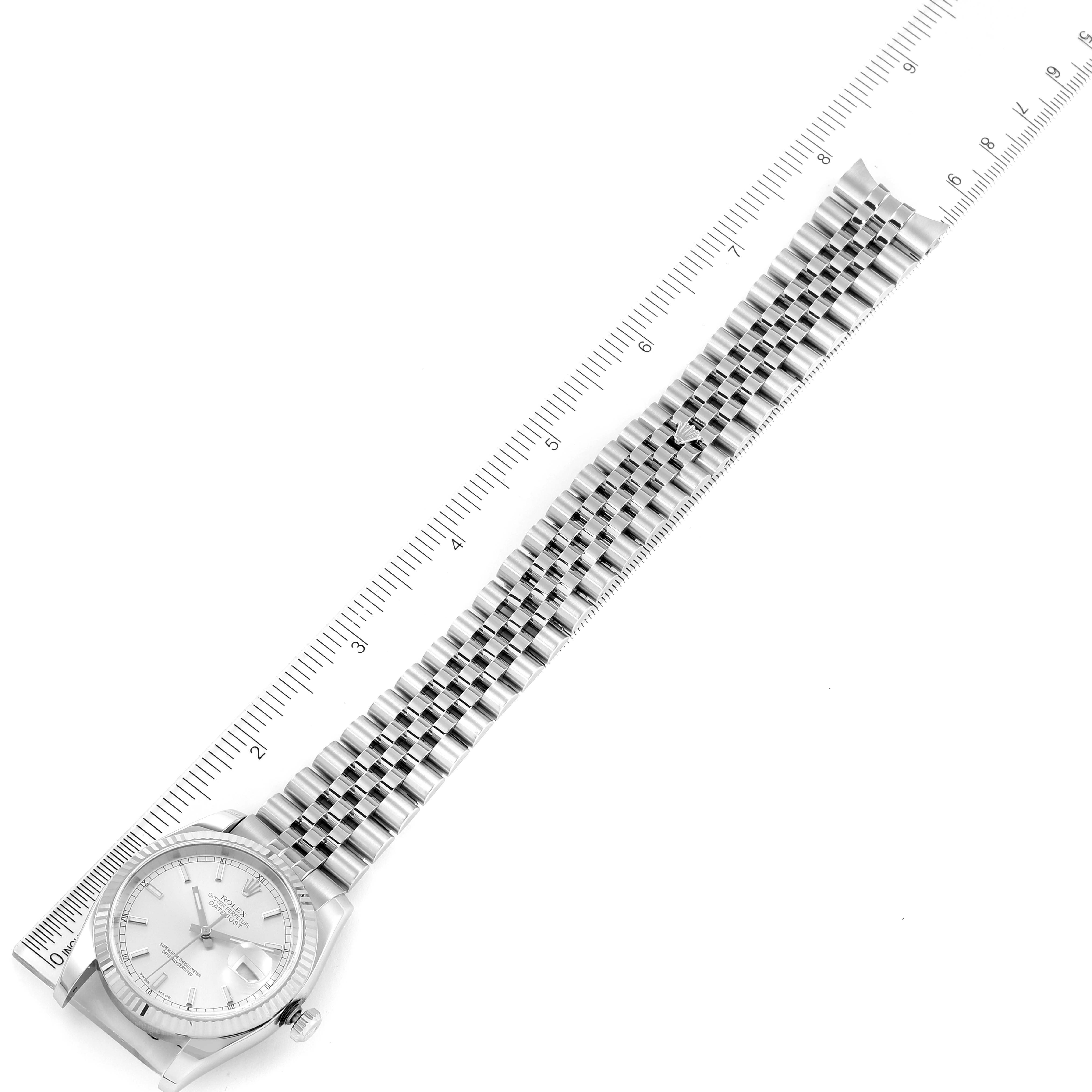 The image shows a Rolex Datejust 116234 Men's Stainless Steel Silver Dial 116234 Men's Stainless Steel Silver Dial watch laid flat next to a ruler, highlighting its bracelet and dial face.