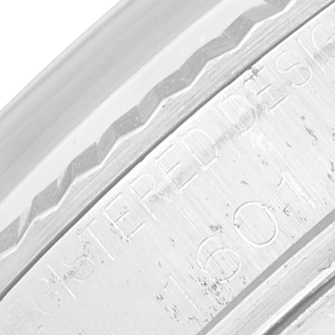 The image shows a close-up of the engraved bezel and part of the case of a Rolex Vintage Collection 1601 Men's Stainless Steel Silver Dial 1601 Men's Stainless Steel Silver Dial watch.