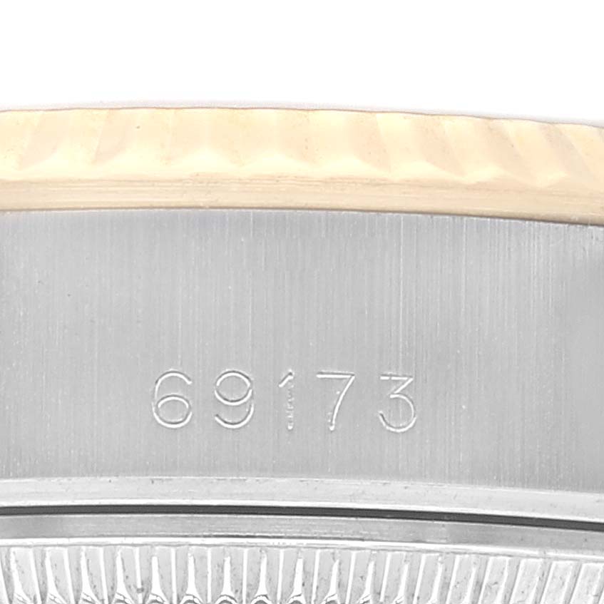 The image shows a close-up of the side of a Rolex Datejust 69173 Women's Steel and Gold (two tone) Champagne Dial 69173 Women's Steel and Gold (two tone) Champagne Dial watch, focusing on the engraved serial number and part of the bezel.