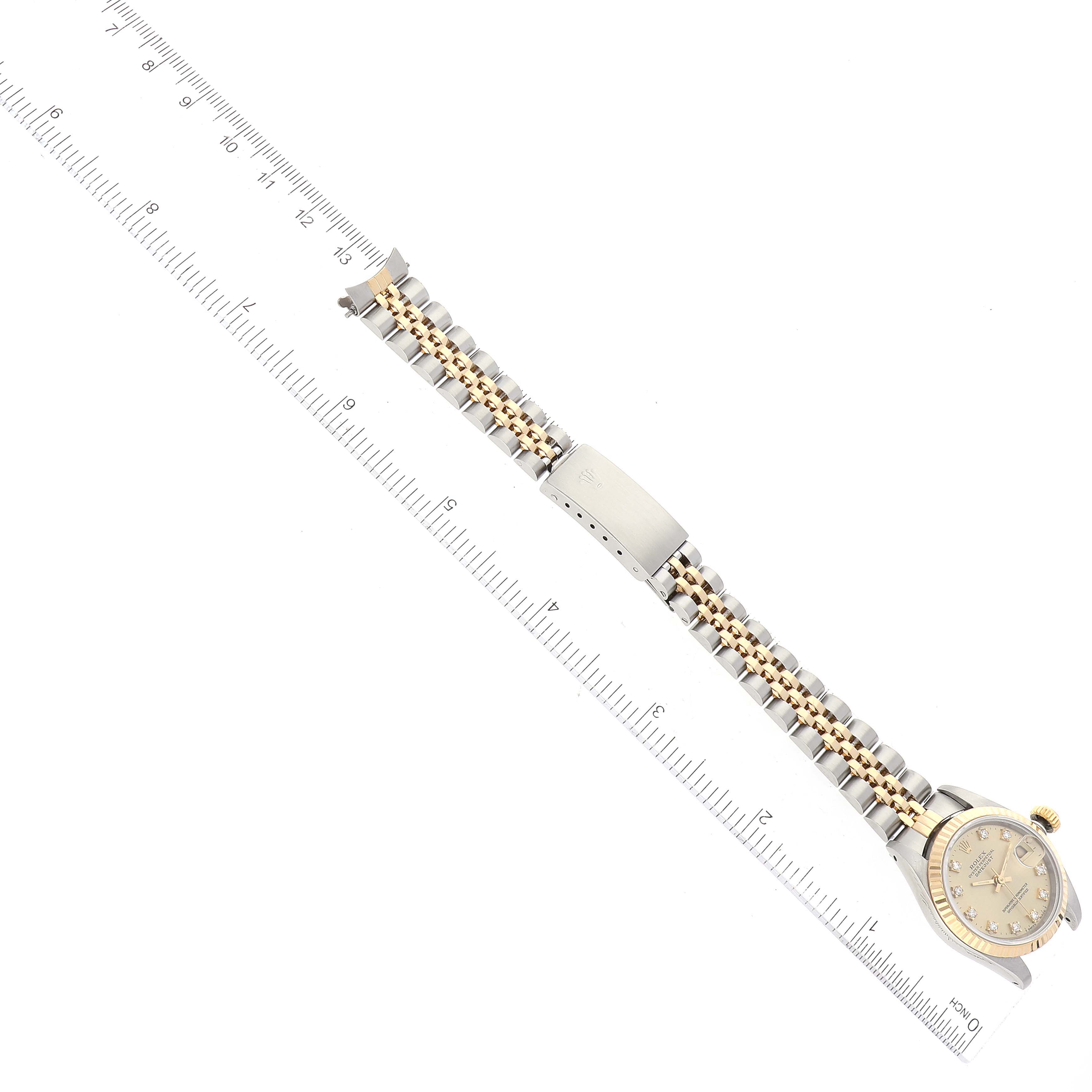 The image shows a Rolex Datejust 69173 Women's Steel and Gold (two tone) Champagne Dial 69173 Women's Steel and Gold (two tone) Champagne Dial watch laid flat with its bracelet fully extended, alongside a measuring ruler.