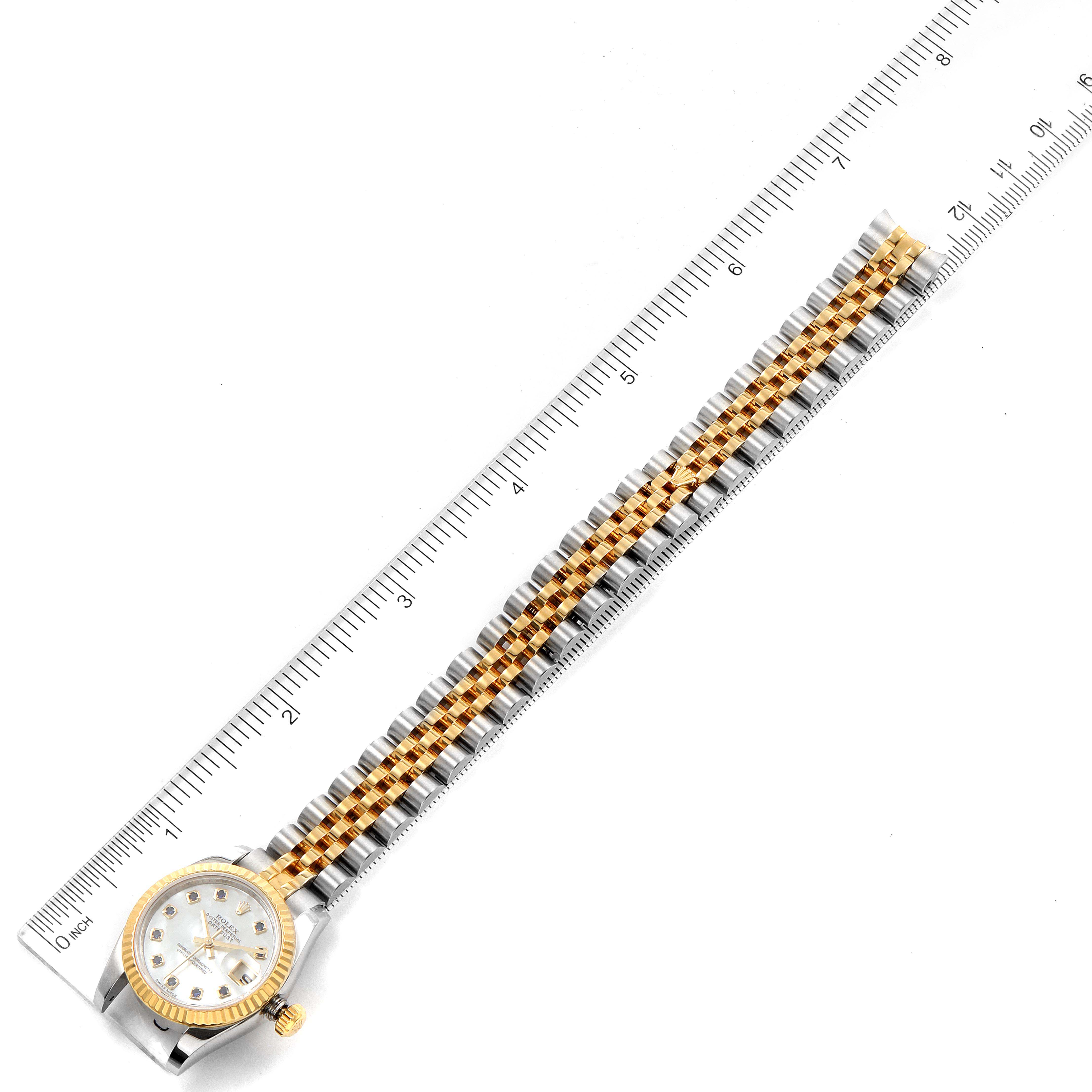 The image shows a top-down view of the Rolex Datejust 179173 Women's Steel and Gold (two tone) Mother of Pearl Dial 179173 Women's Steel and Gold (two tone) Mother of Pearl Dial watch, highlighting the face and the full length of the band alongside a ruler.