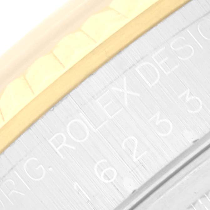 This close-up image shows the Datejust model by Rolex, featuring part of the bezel and engraved text on the case.