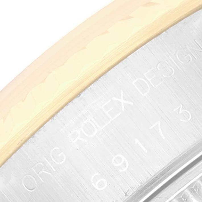 This image shows a close-up of the engravings on the side of a Rolex Datejust 69173 Women's Steel and Gold (two tone) Grey Dial 69173 Women's Steel and Gold (two tone) Grey Dial watch case, featuring "Rolex Design."