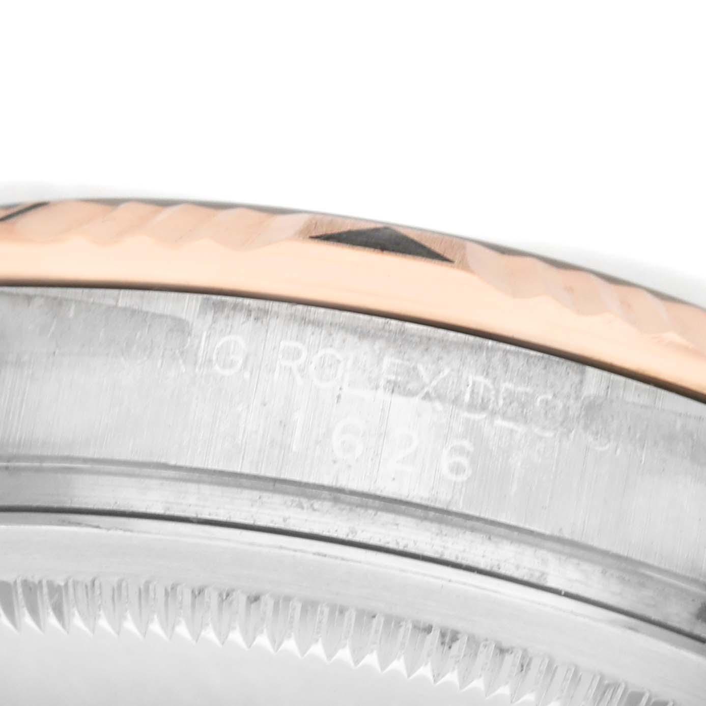 The image shows a close-up of the bezel and edge of the case back of a Rolex Turn-o-Graph 116261 Men's Steel and Gold (two tone) White Dial watch, highlighting its engravings.