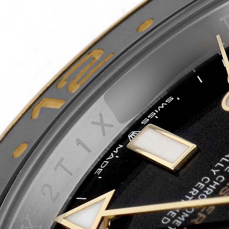 The image shows a close-up of the bezel and dial of a Rolex GMT-Master 126713GRNR Men's Steel and Gold (two tone) Black Dial watch, highlighting the indices and part of the hands.