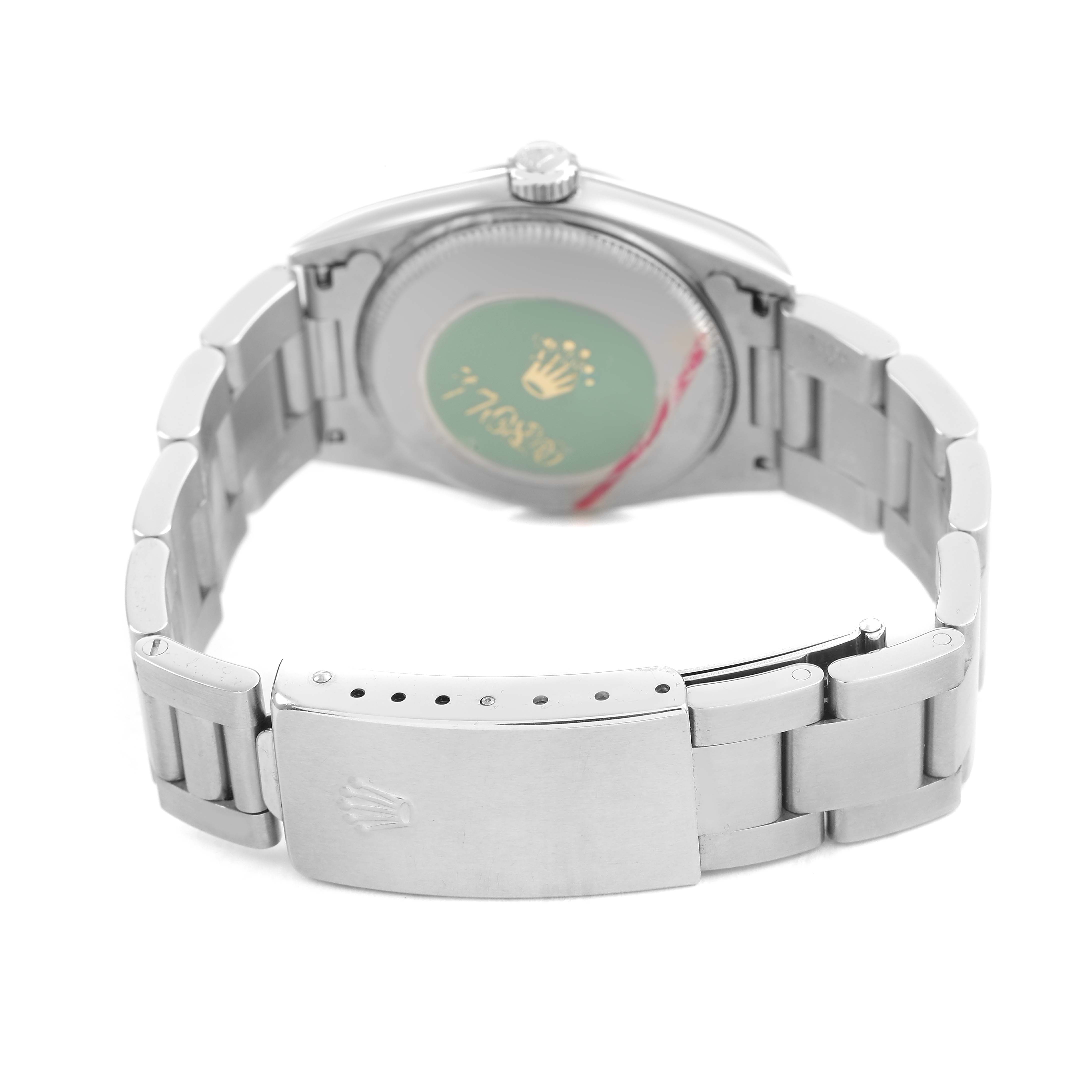 The image shows the back of a Rolex Oyster Perpetual 77080 Women's Stainless Steel Blue Dial watch, highlighting its bracelet clasp and case back.
