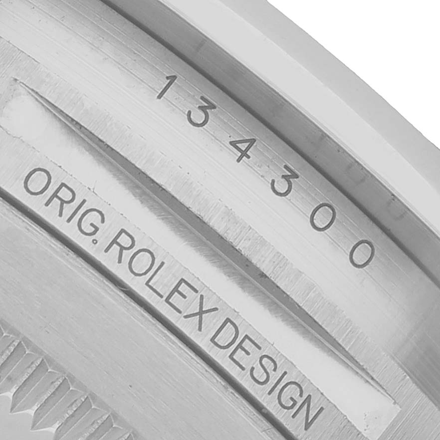 The image shows the side case engraving of the Rolex Oyster Perpetual 134300 Men's Stainless Steel Green Dial, including the model number and "Orig. Rolex Design" text.