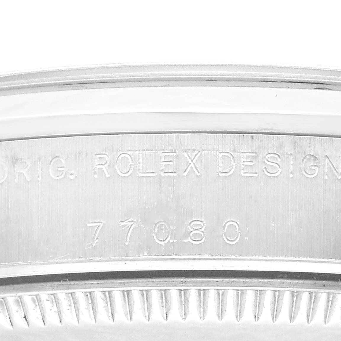 The image shows the engraved side of a Rolex Mid-Size 77080 Women's Stainless Steel Blue Dial 77080 Women's Stainless Steel Blue Dial watch case, focusing on its model number and brand inscription.