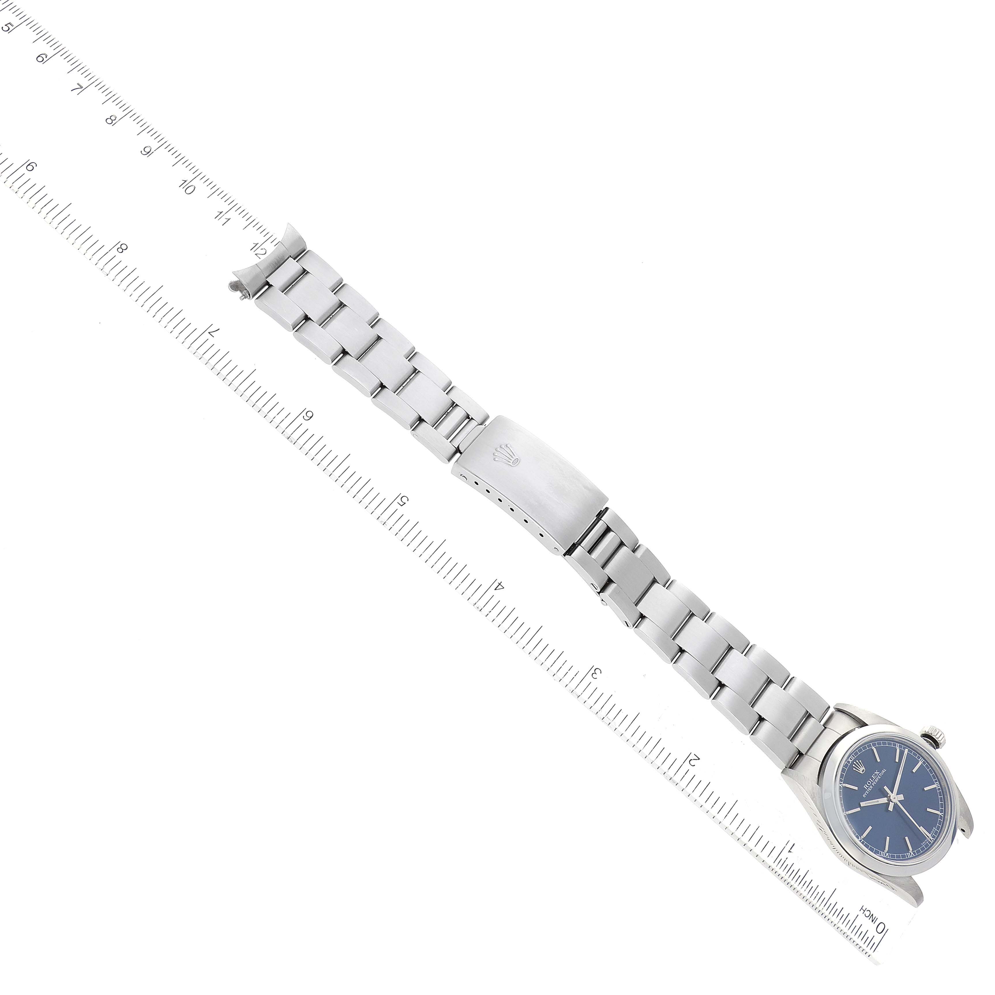 The image shows a Rolex Mid-Size 77080 Women's Stainless Steel Blue Dial 77080 Women's Stainless Steel Blue Dial model watch with a blue dial and stainless steel bracelet, laid flat next to a ruler.