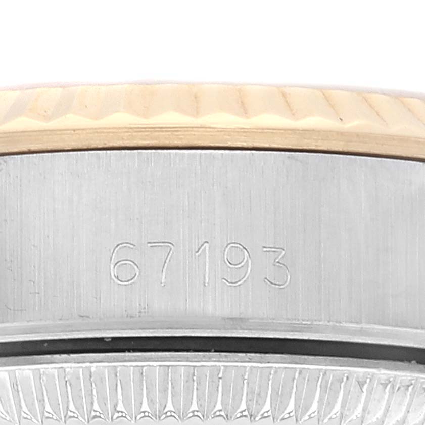 This image shows a close-up of the serial number "67193" on the side of a Rolex Oyster Perpetual 67193 Women's Steel and Gold (two tone) Champagne Dial 67193 Women's Steel and Gold (two tone) Champagne Dial watch bezel and case.