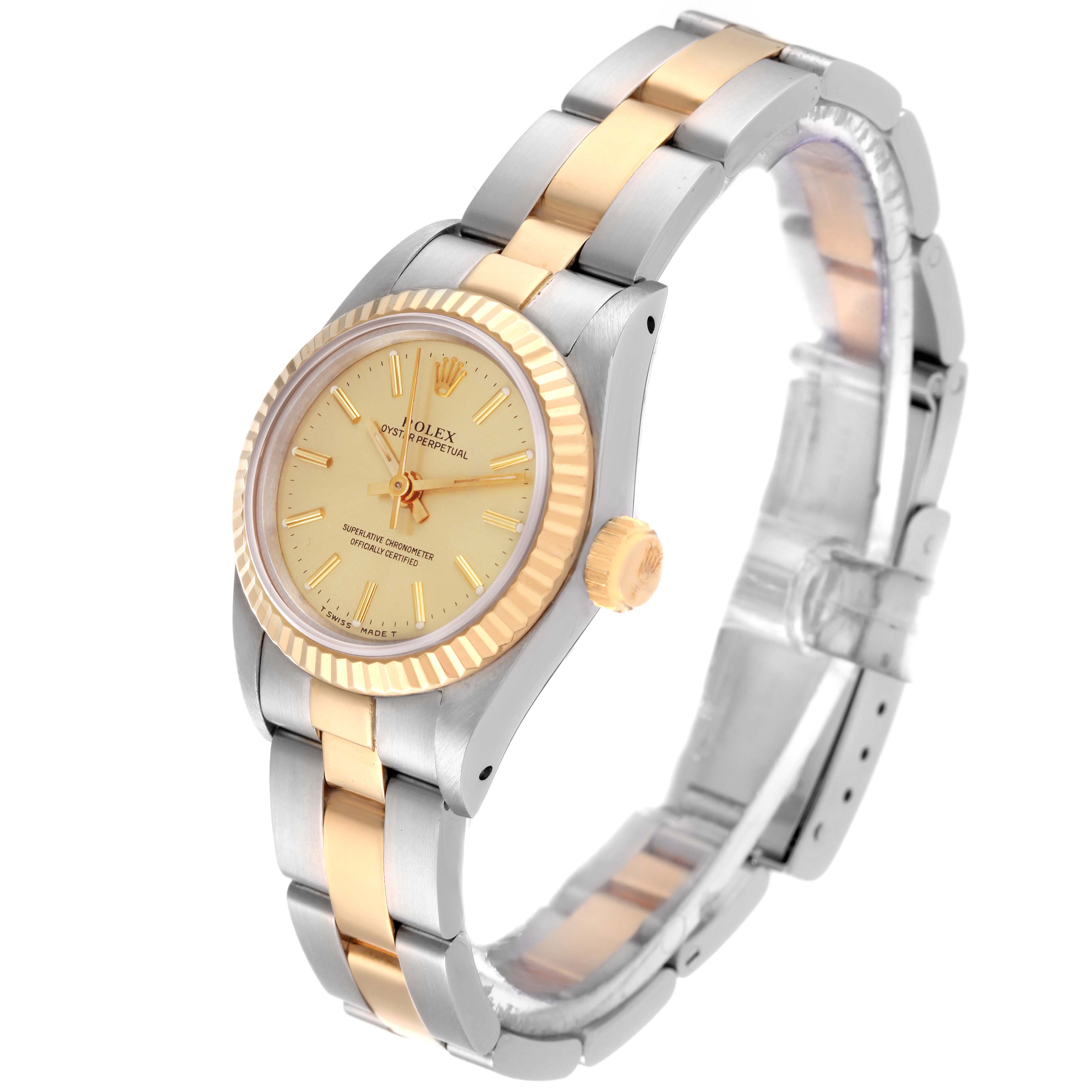 This Rolex Oyster Perpetual 67193 Women's Steel and Gold (two tone) Champagne Dial 67193 Women's Steel and Gold (two tone) Champagne Dial watch is shown at an angle showcasing the dial, fluted bezel, crown, and the two-tone bracelet.